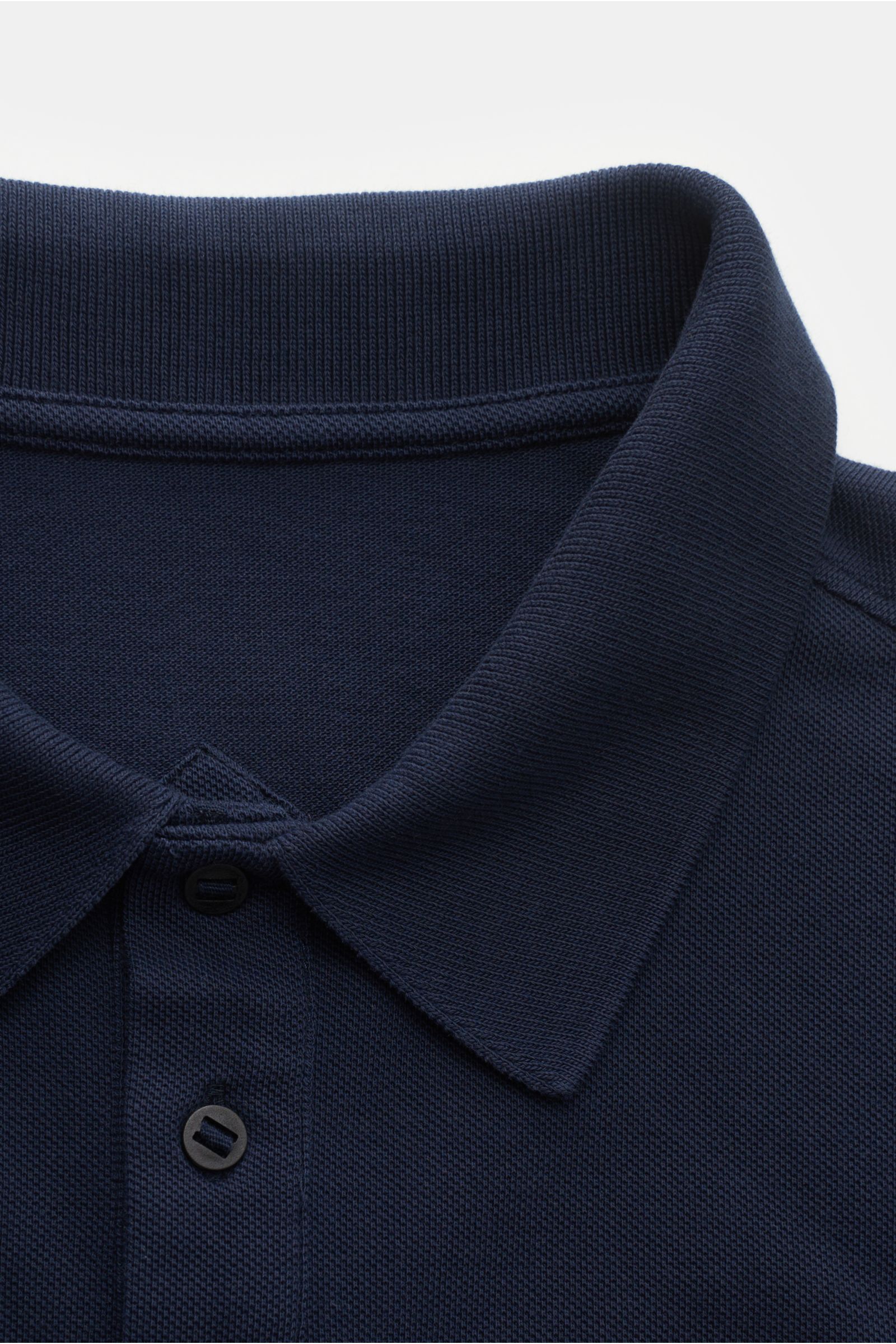 Close-up front view of the navy Canada Goose Poloshirt 'Beckley' showing the textured cotton piqué fabric, typical polo collar, three-button placket, and detailed stitching. Das klassische Poloshirt 'Beckley' ist ein Must
