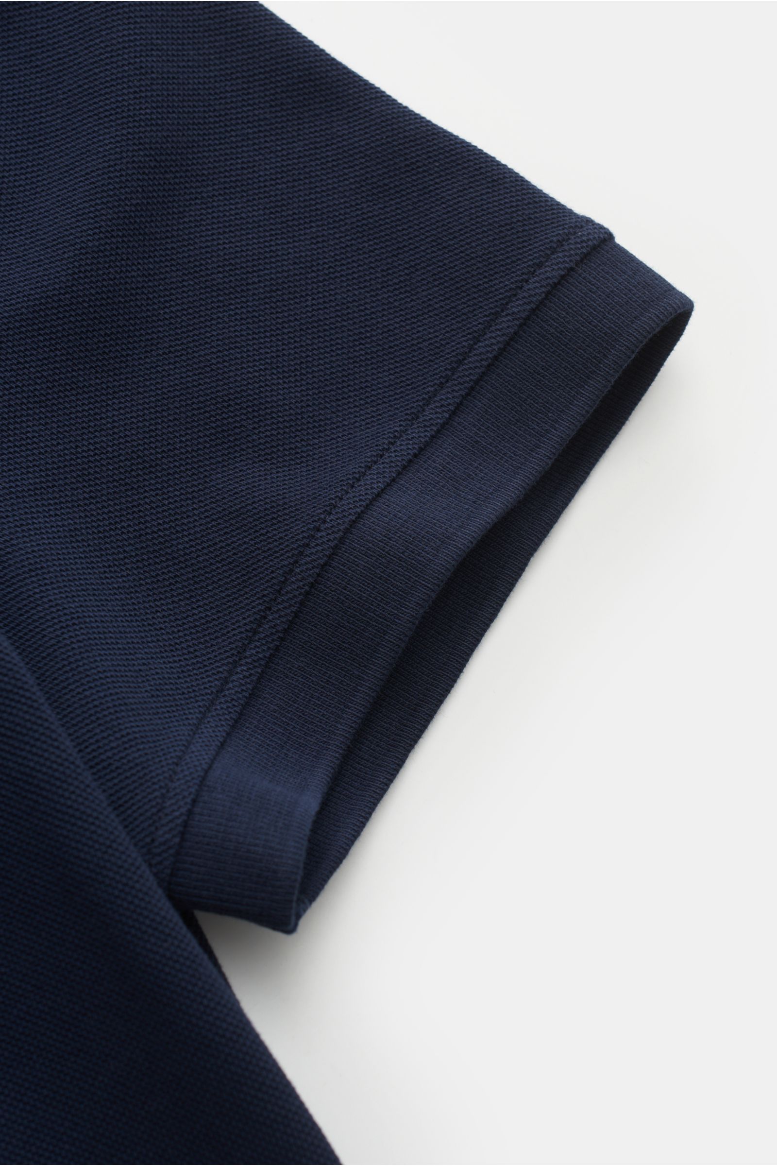 Close-up of the sleeve of the Canada Goose Poloshirt 'Beckley' navy, showing textured cotton piqué fabric and ribbed cuff from a top-down angle.

Description: Das klassische Poloshirt 'Beckley' ist ein Must-have in der sp