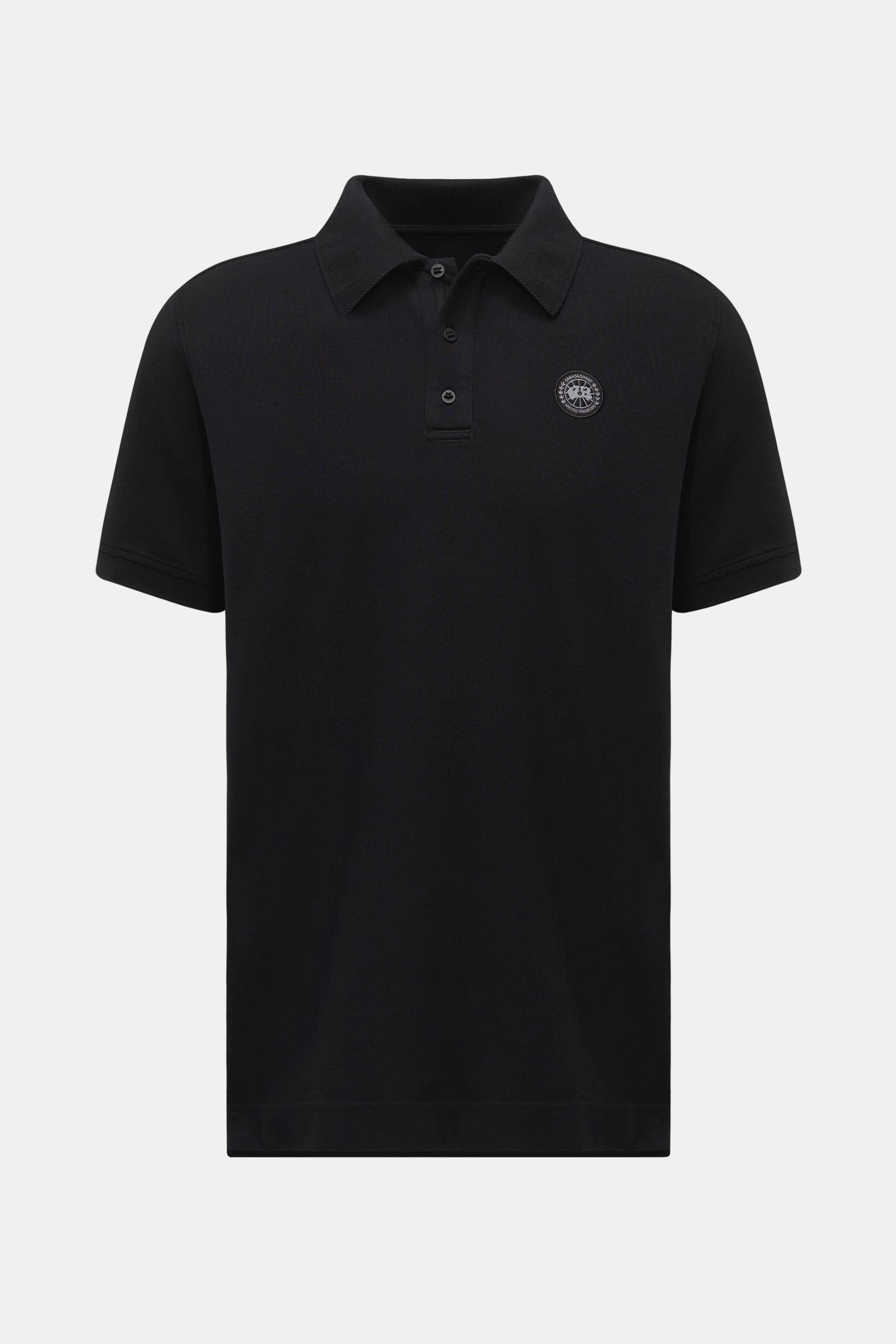 Front view of Canada Goose Poloshirt schwarz, a classic black polo shirt made of pure cotton piqué with a structured feel, three-button placket, chest patch, flexible cuffs, side slits, and slightly extended back.

Description: Das klassische Poloshirt