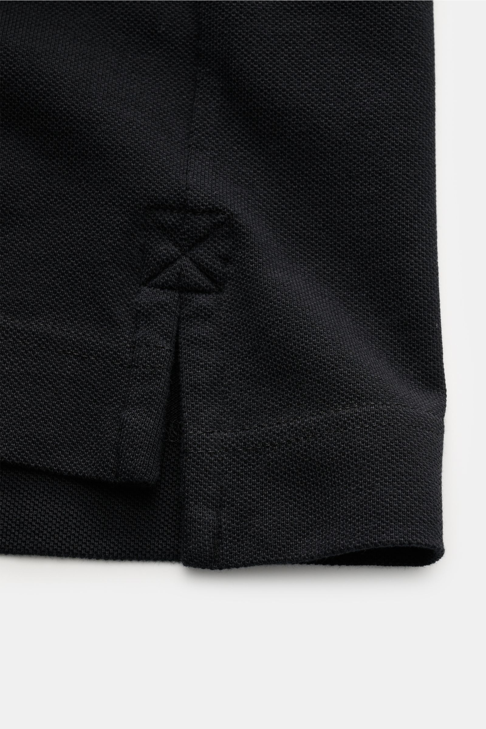 Close-up shot of the side hem and side slit of the Canada Goose Poloshirt schwarz, showing the textured black cotton piqué fabric and detailed stitching.

Das klassische Poloshirt ist ein Must-have in der sportiven Herrengarderobe: Aus Baumwoll-Piqué g