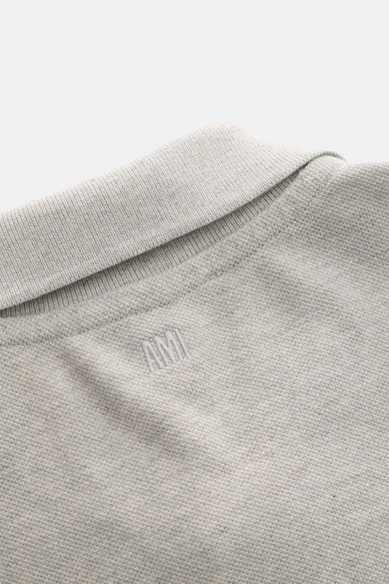 A close-up rear view of the Ami Paris Poloshirt grau meliert showing the fine piqué texture, ribbed collar, and subtle 'A' logo stitching on organic cotton fabric. Ein schöner Klassiker unter den Poloshirts: Das ikonisches Piqué-Modell aus reiner Bio-B