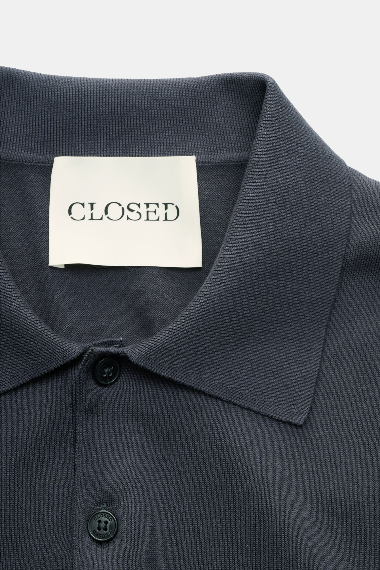 Closed Kurzarm-Strickpolo graublau aus Baumwolle, Feinstrick, weicher Griff, Slim Fit, gestrickter Polokragen, tiefe Vier-Knopf-Leiste, Detailfoto von oben.