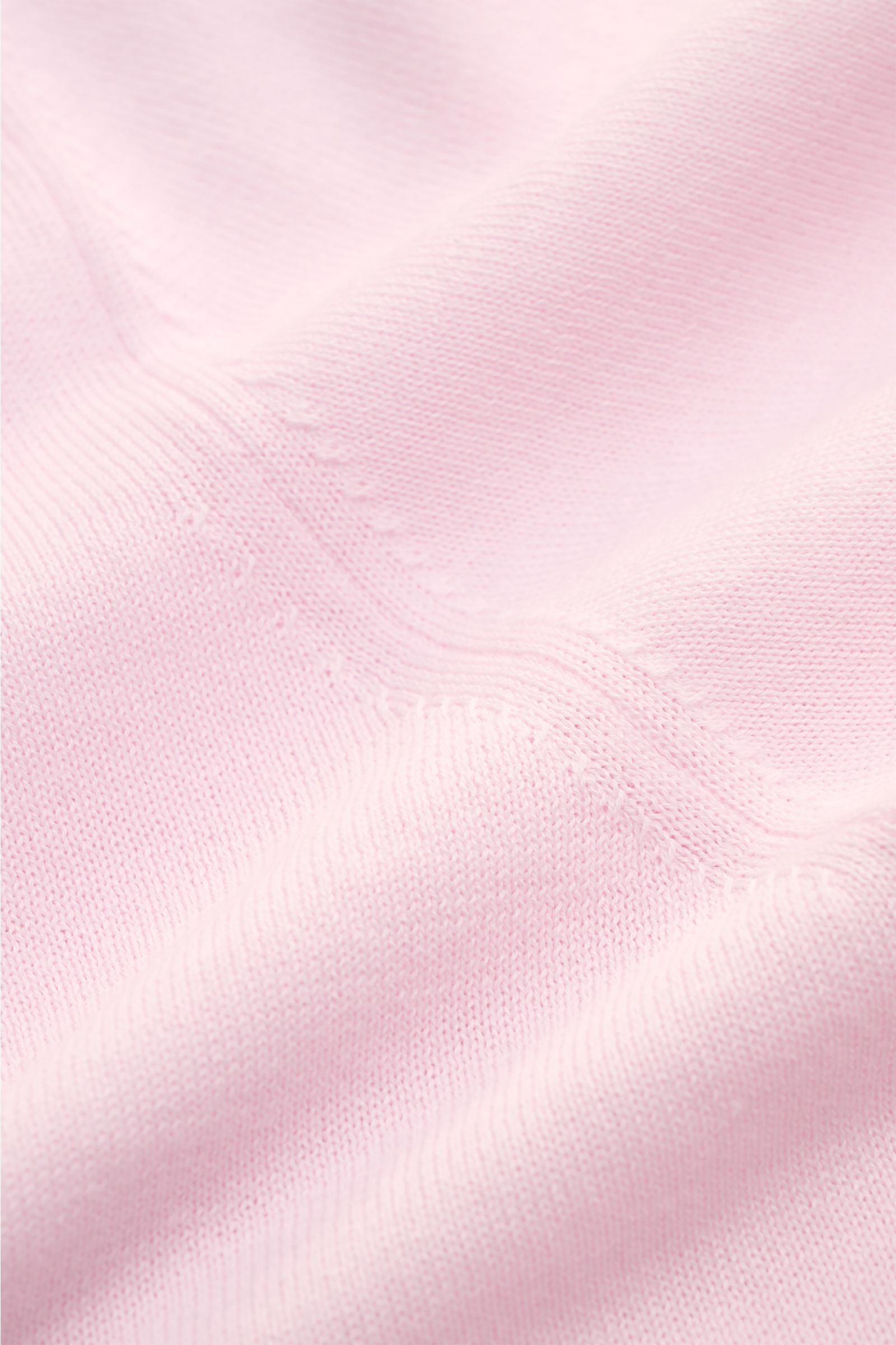 Close-up of the fine knit fabric texture of the Closed Short sleeve knit polo rose, photographed from above showing soft pink cotton material.

This CLOSED short-sleeved knit polo in fine knit fabric is made from pure cotton, the perfect casual and sty