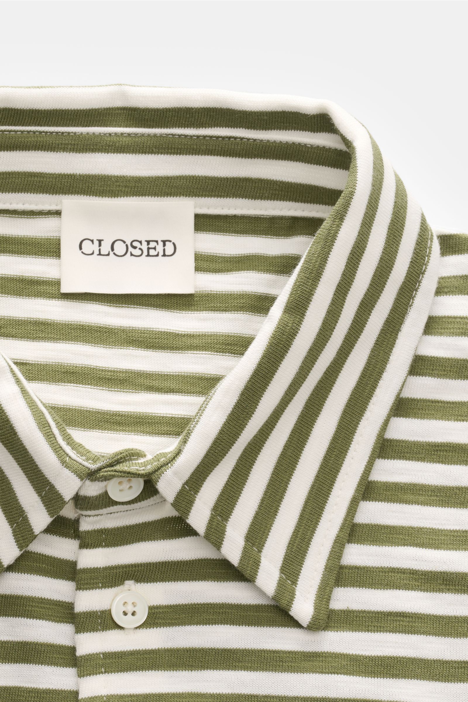 Close-up front view of Closed Short sleeve knit polo green/cream striped showing collar and buttons, made of fine pure cotton knit.

This CLOSED short sleeve knit polo is made from pure, soft cotton and is a sporty essential for the new season.
