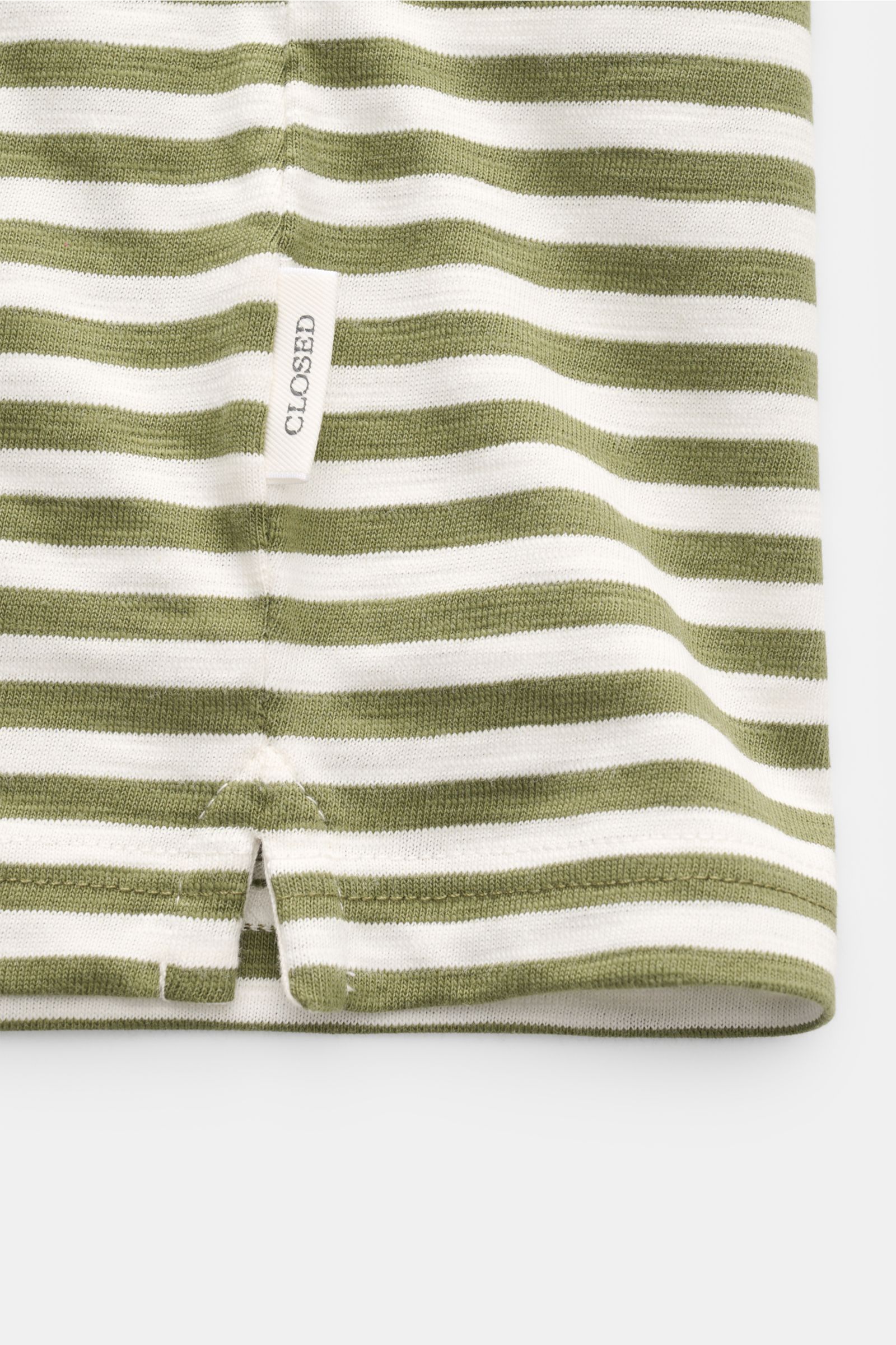 Close-up view of the hem of the Closed Short sleeve knit polo green/cream striped showing fine knit fabric, side vents, and brand label.

This CLOSED short sleeve knit polo is made from pure, soft cotton and is a sporty essential for the new season.