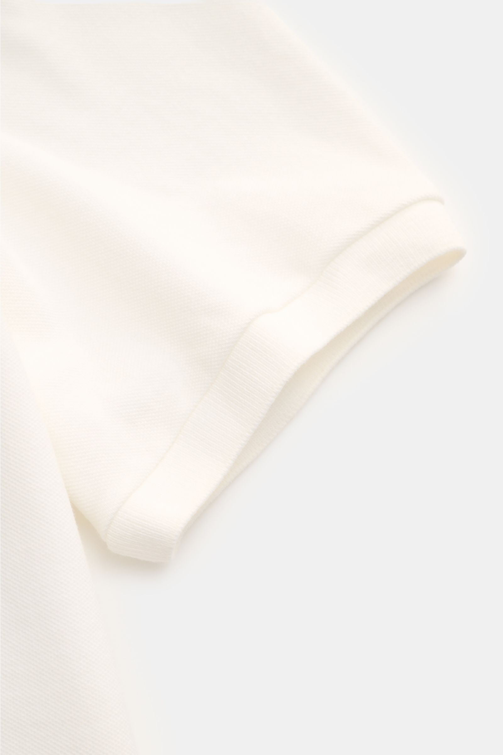 C.P. Company Poloshirt weiß, Detailaufnahme der kurzen Ärmel mit elastischem Bündchen aus Baumwoll-Piqué, Slim Fit, Pigment-Dye.