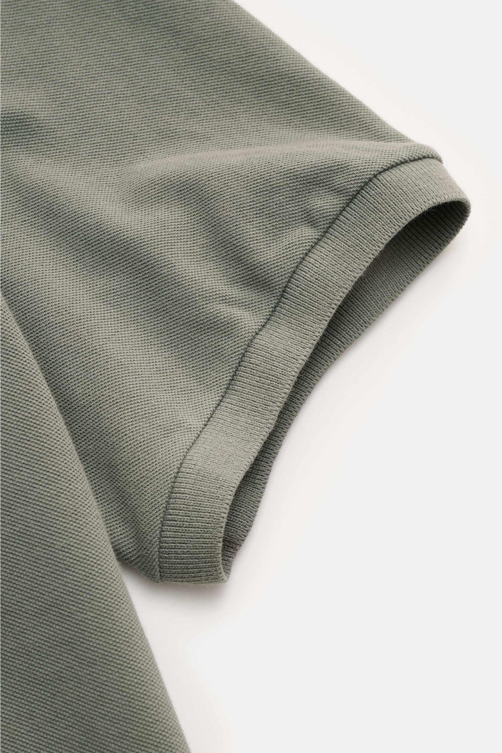 Nahaufnahme des Ärmels vom C.P. Company Poloshirt grau aus Baumwoll-Piqué mit elastischem Bündchen, Slim Fit und Pigment-Dye-Färbung.