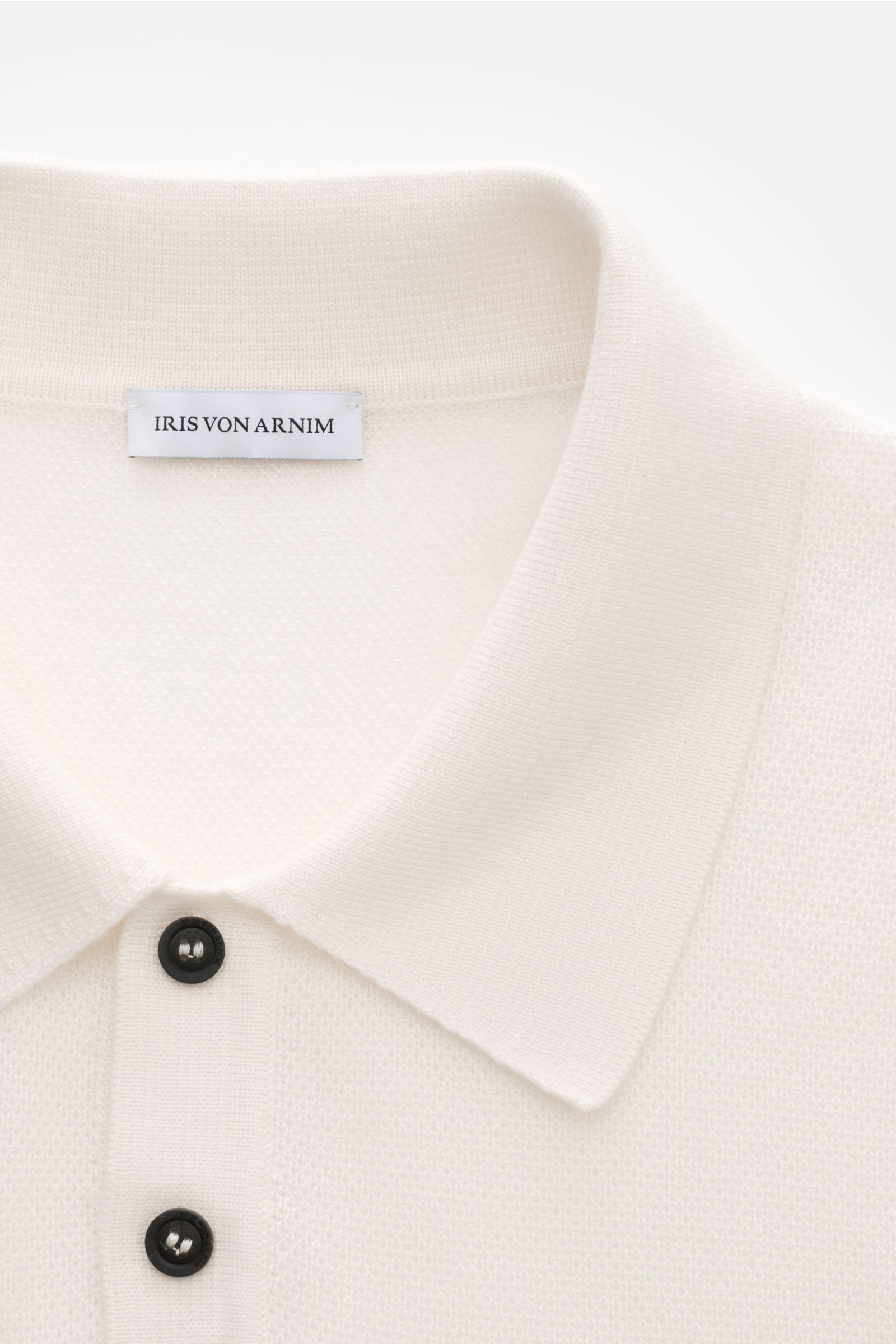 Close-up front view of Iris von Arnim Kurzarm-Strickpolo 'Pavion' offwhite showing soft cashmere and silk knit, classic collar, and two-button placket. Luxuriöser Allrounder: Das edle Strickpolo von IRIS VON ARNIM verbindet Exklusivität mit unvergleichlic