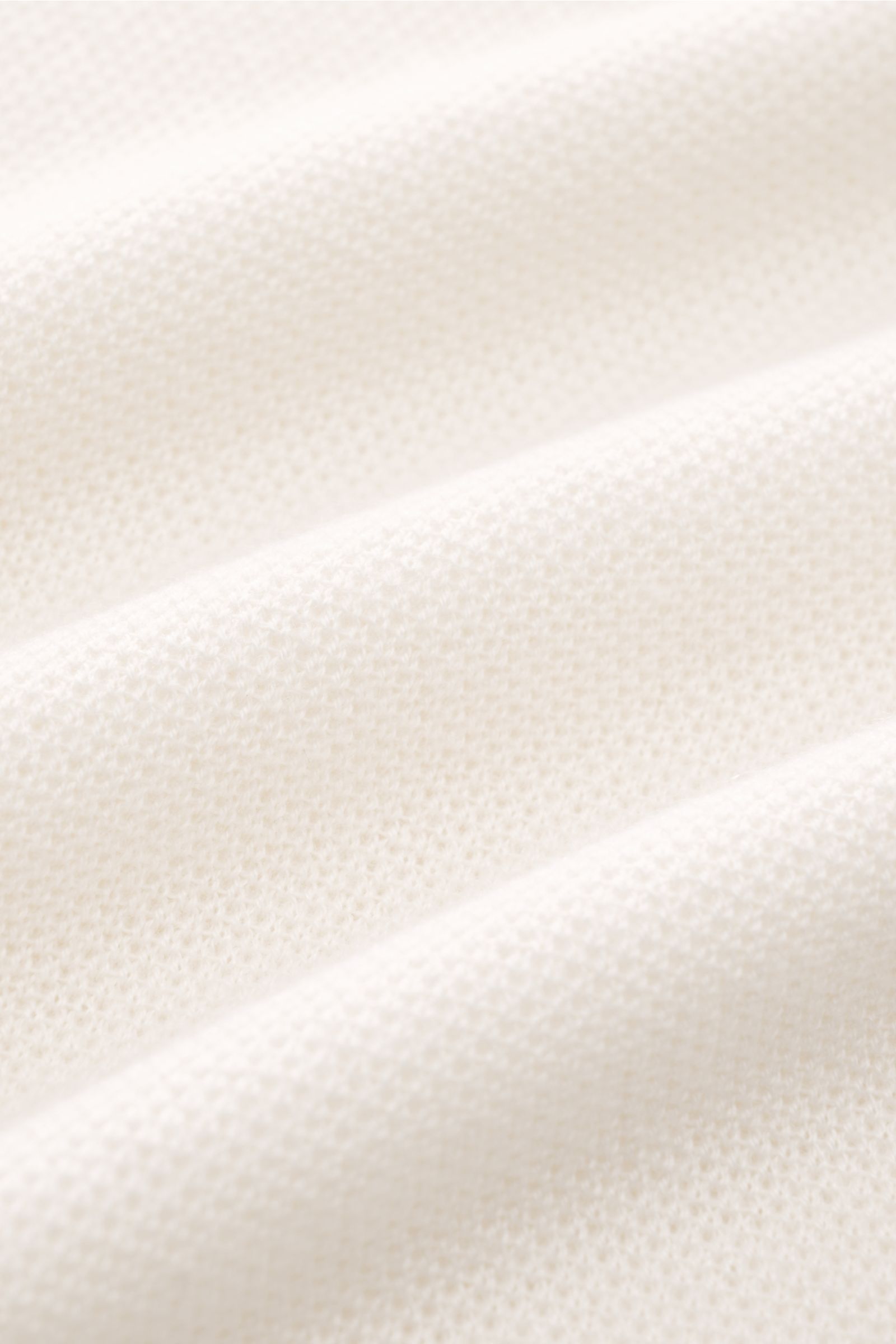 Close-up front view of the offwhite Iris von Arnim Kurzarm-Strickpolo 'Pavion' fabric, showing soft cashmere and silk knit texture.

Luxuriöser Allrounder: Das edle Strickpolo von IRIS VON ARNIM verbindet Exklusivität mit unvergleichlichem Komfort und 