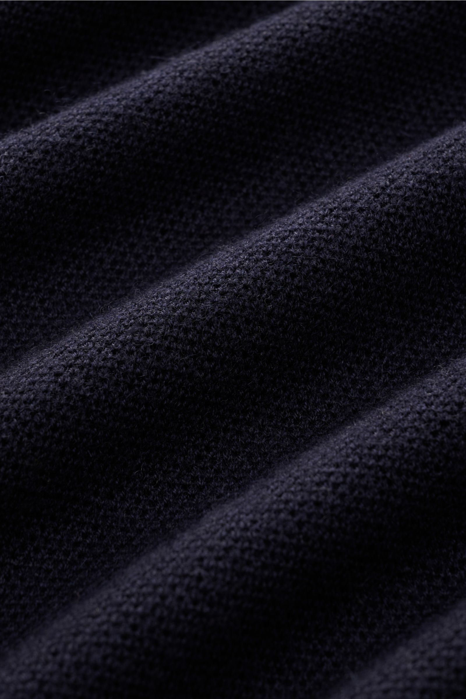 Close-up textile view of the Iris von Arnim Kurzarm-Strickpolo 'Pavion' navy, photographed from a macro perspective showing its soft, textured knit fabric. Luxuriöser Allrounder: Das edle Strickpolo von IRIS VON ARNIM verbindet Exklusivität mit unvergleic