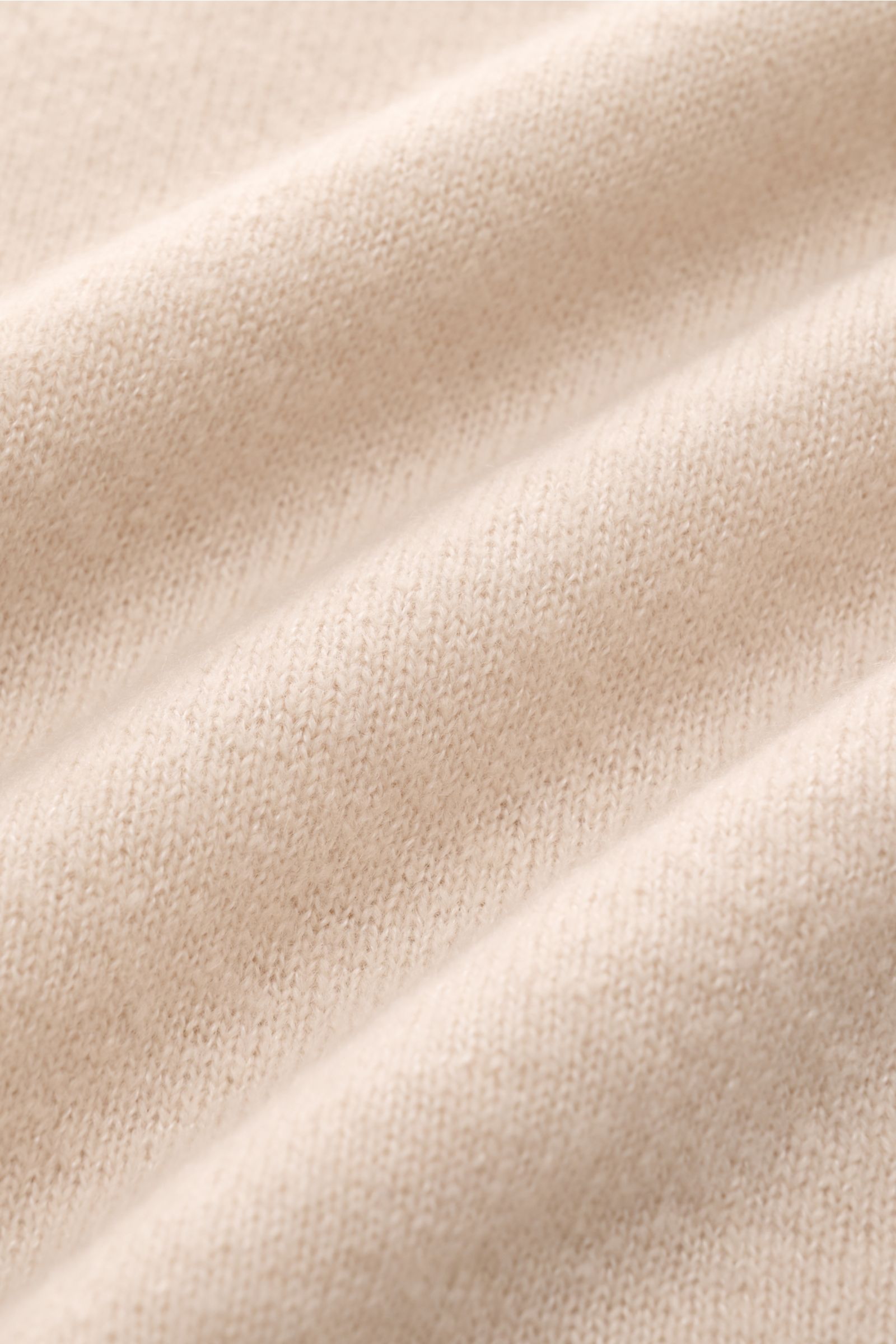 Close-up front view of the beige Iris von Arnim Kurzarm-Strickpolo 'Ameca' knit fabric, showcasing its soft texture and fine weave. Luxuriöser Allrounder: Das edle Strickpolo von IRIS VON ARNIM verbindet Exklusivität mit unvergleichlichem Komfort und wird