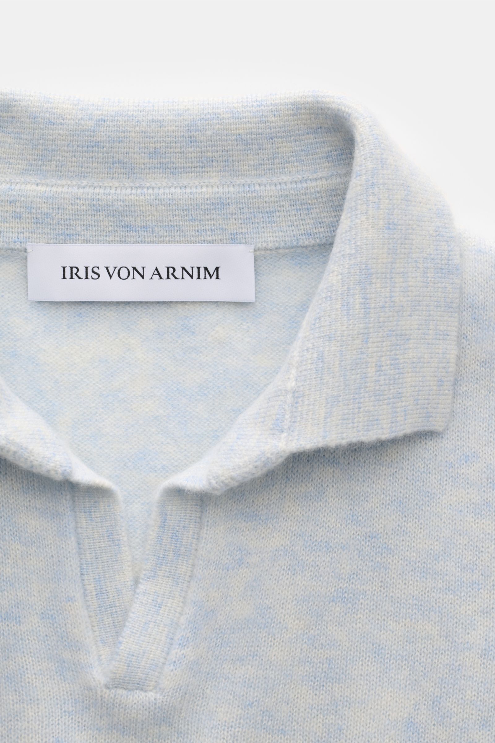 Close-up front view of Iris von Arnim Kurzarm-Strickpolo 'Ameca' pastellblau meliert showing soft knit fabric and classic polo collar. Luxuriöser Allrounder: Das edle Strickpolo von IRIS VON ARNIM verbindet Exklusivität mit unvergleichlichem Komfort un