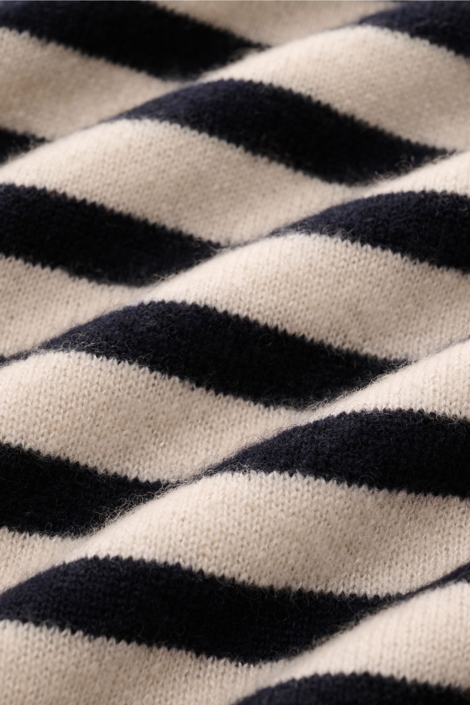 Close-up side view of the beige and dark navy striped knit fabric of the Iris von Arnim Kurzarm-Strickpolo 'Ameca', made from a soft cashmere and silk blend with a regular fit and classic polo collar. Luxuriöser Allrounder: Das edle Strickpolo von IRIS VO