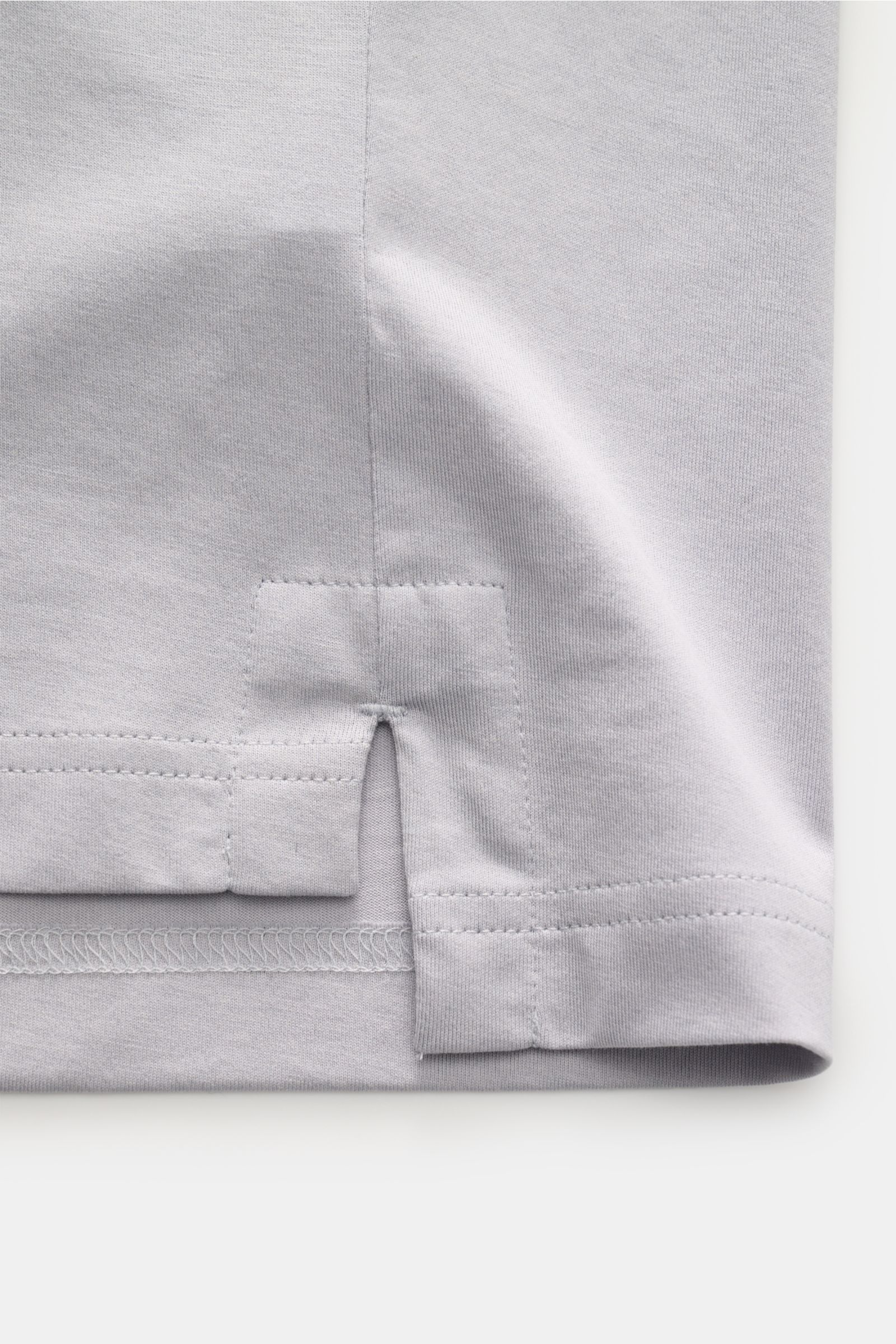 Nahaufnahme des Saumdetails mit kurzen Schlitzen des Stefan Brandt Jersey-Poloshirt 'Luca' hellgrau aus weichem Pima-Baumwoll-Jersey.