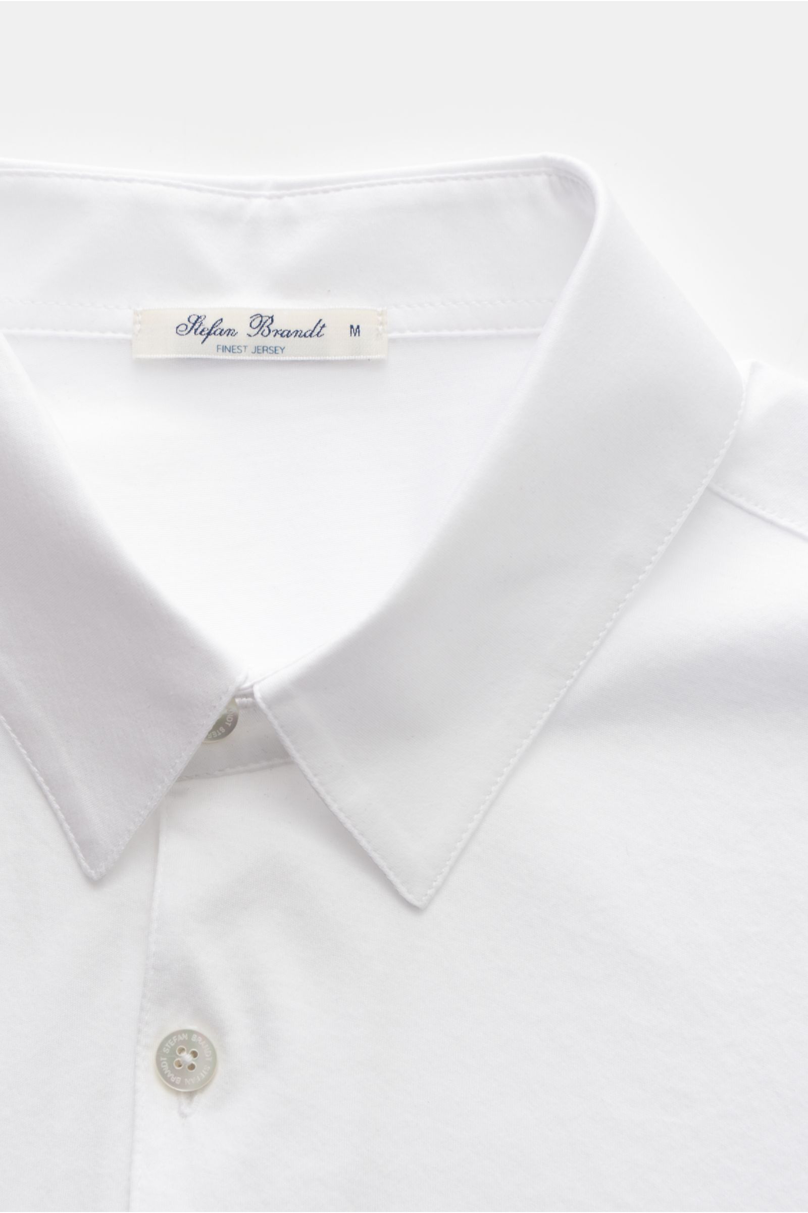 Close-up front view of Stefan Brandt Jersey-Poloshirt 'Luca' weiß showcasing collar, three-button placket, and soft white organic Pima cotton fabric.

Das exklusive Jersey-Poloshirt von STEFAN BRANDT begeistert mit hochwertiger Bio-Pima-Baumwolle, welc