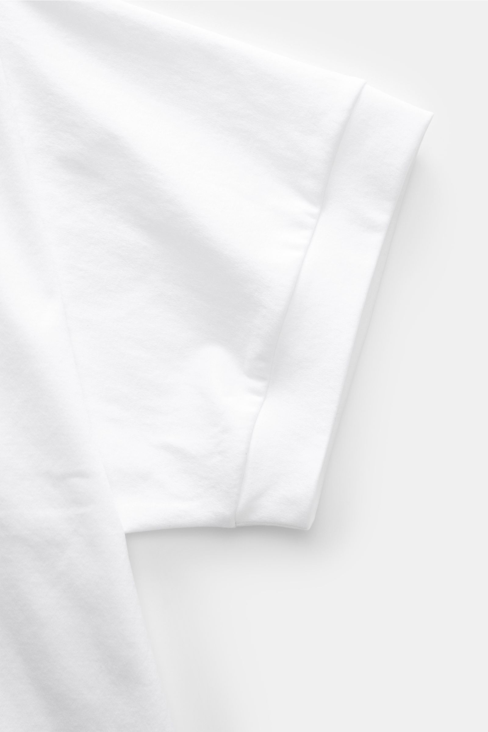Close-up of the sleeve of the Stefan Brandt Jersey-Poloshirt 'Luca' weiß, shown from the side to highlight the smooth, soft cotton fabric and flexible hem cuffs. Feinster Komfort für jeden Tag: Das exklusive Jersey-Poloshirt 'Luca' von 
