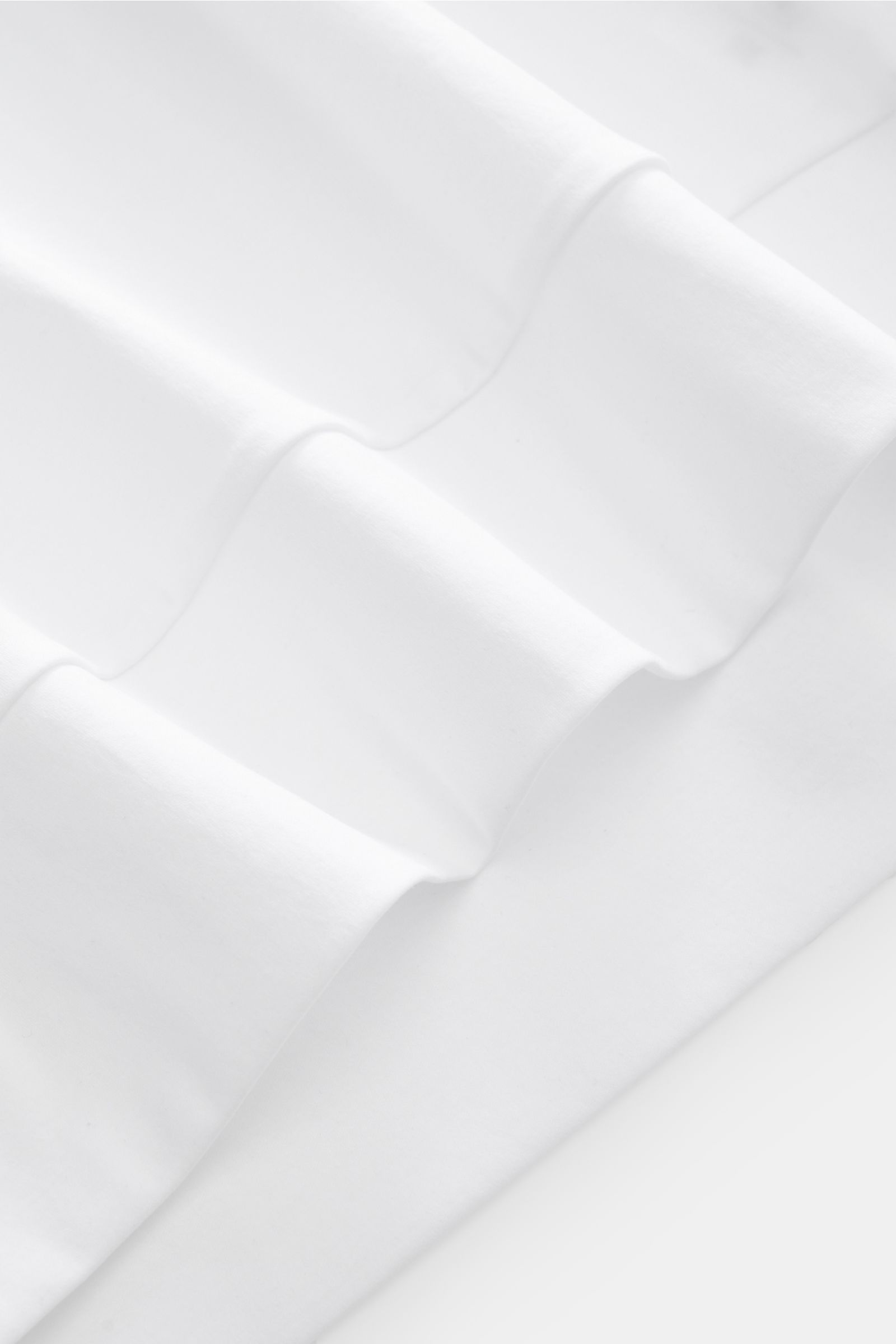 Close-up front view of Stefan Brandt Jersey-Poloshirt 'Luca' weiß fabric showing soft, smooth Pima cotton texture and fine knit. Feinster Komfort für jeden Tag: Das exklusive Jersey-Poloshirt 'Luca' von 