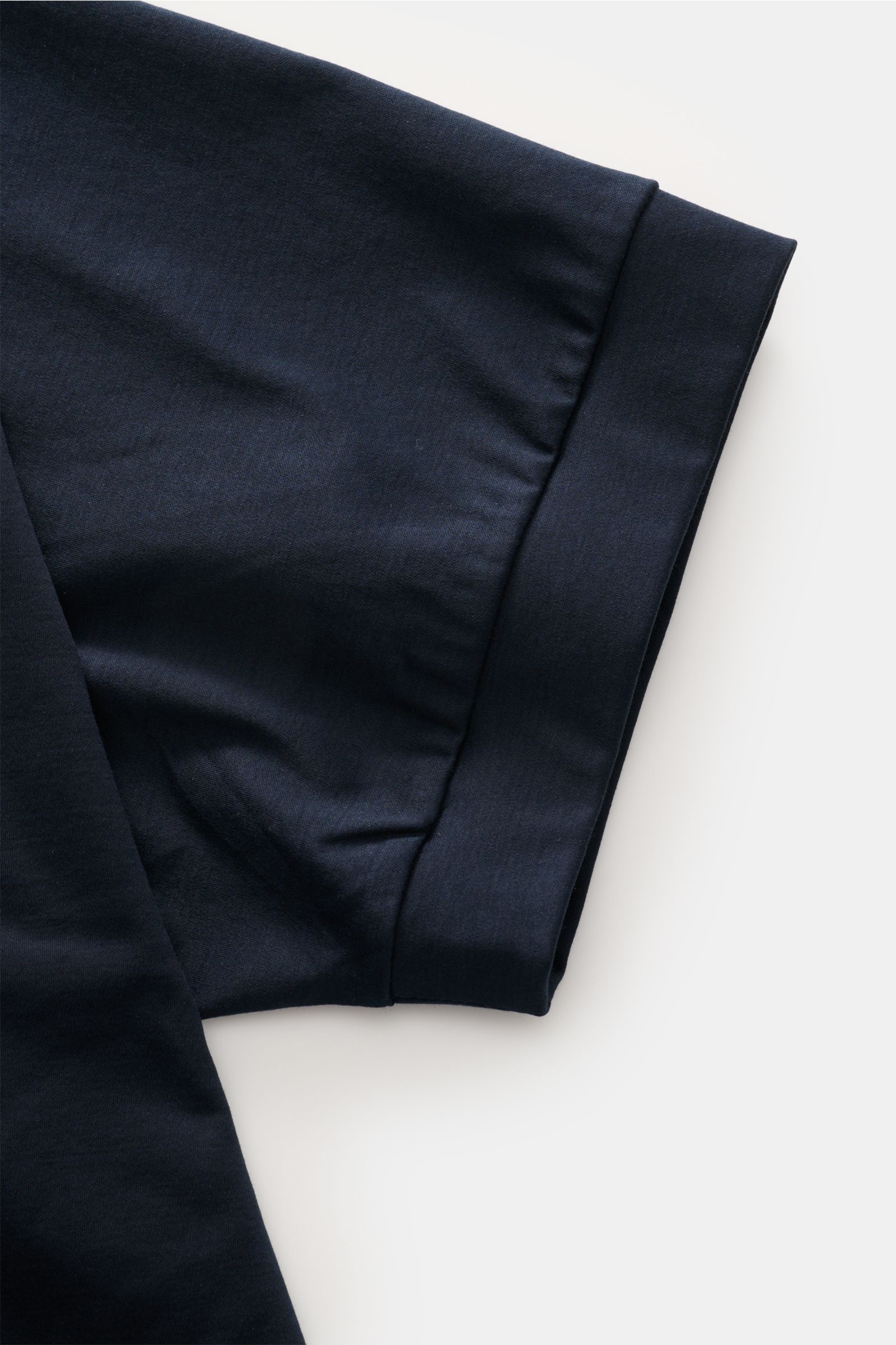 Close-up of the sleeve and cuff of the Stefan Brandt Jersey-Poloshirt 'Luca' dark navy, showing fine Pima cotton fabric from a top-down perspective. Feinster Komfort für jeden Tag: Das exklusive Jersey-Poloshirt 'Luca' von 