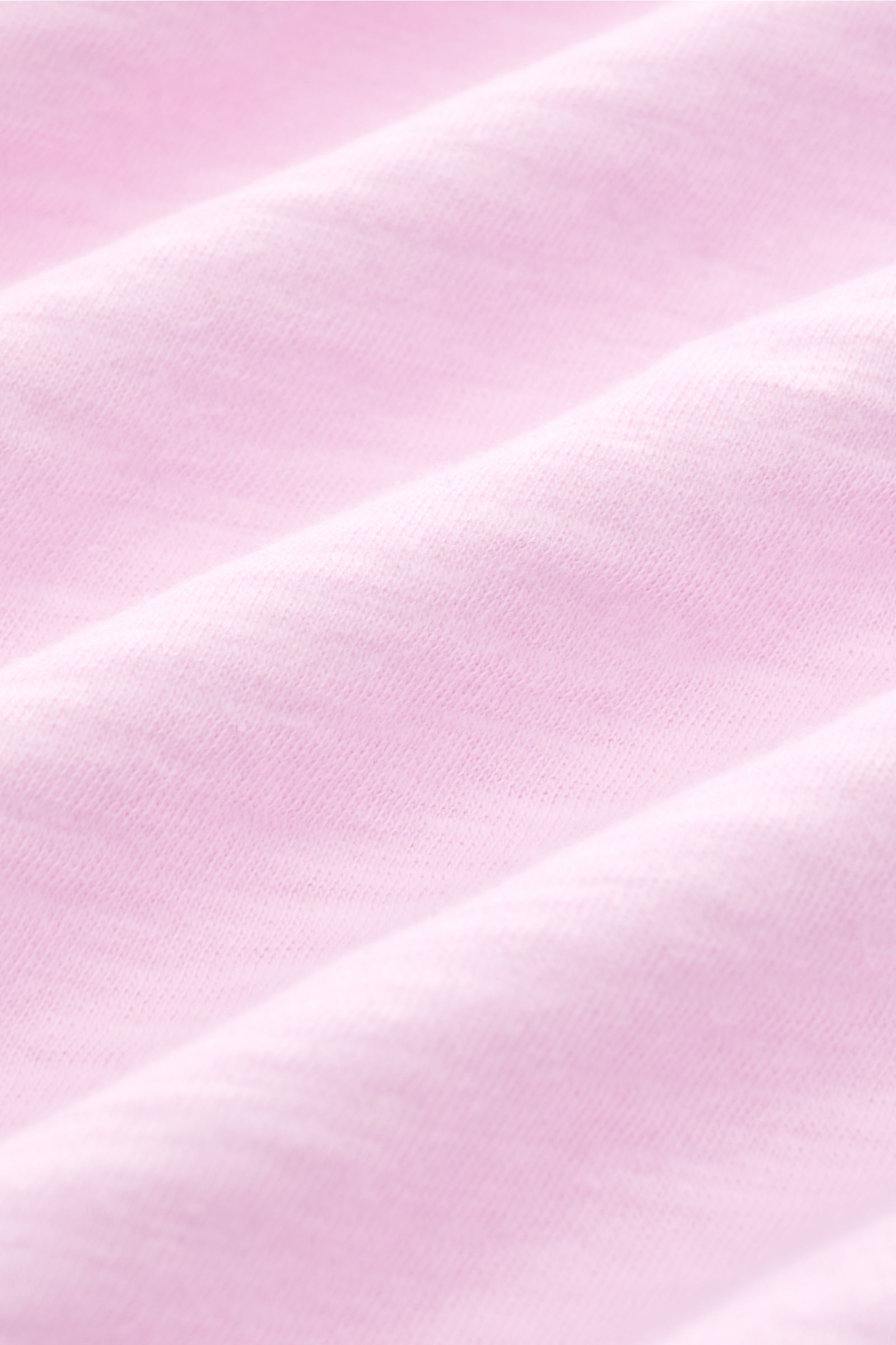 Close-up texture view of the B.F. Knitwear Jersey polo shirt rose mottled in soft pink, photographed from a top angle. Uncomplicated classic: This jersey polo shirt by B.F. KNITWEAR is a versatile basic for the warmer months.Pure cotton