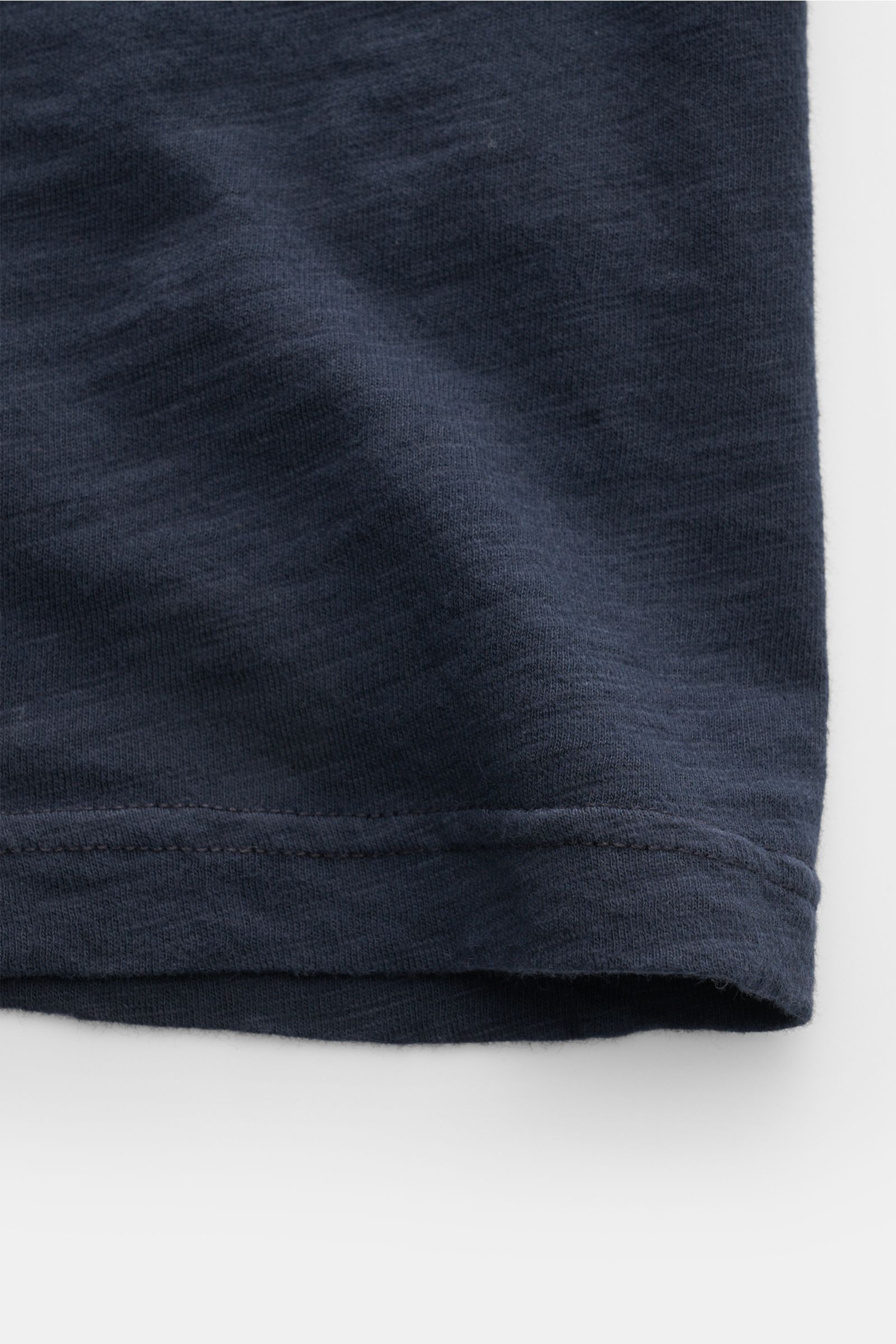 Close-up of the hem of the B.F. Knitwear Jersey polo shirt navy, showing pure cotton fabric, soft feel, slim fit, and classic polo collar from a flat lay perspective. Uncomplicated classic: This jersey polo shirt by B.F. KNITWEAR is a versatile basic for 