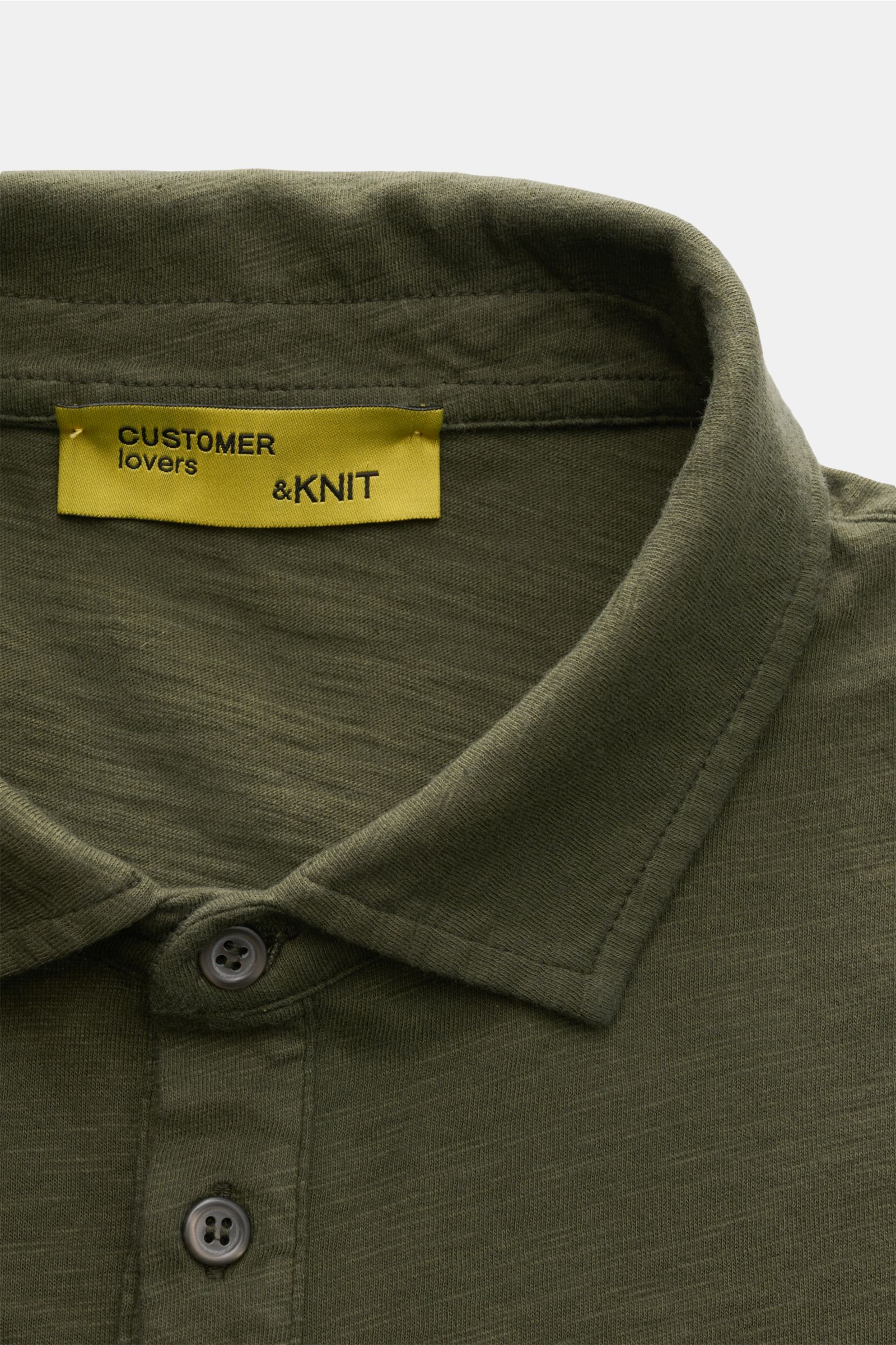 B.F. Knitwear Jersey polo shirt dark olive shown from above, highlighting classic polo collar and button placket. Uncomplicated classic: This jersey polo shirt by B.F. KNITWEAR is a versatile basic for the warmer months. Pure cotton, soft feel, slim fit, 