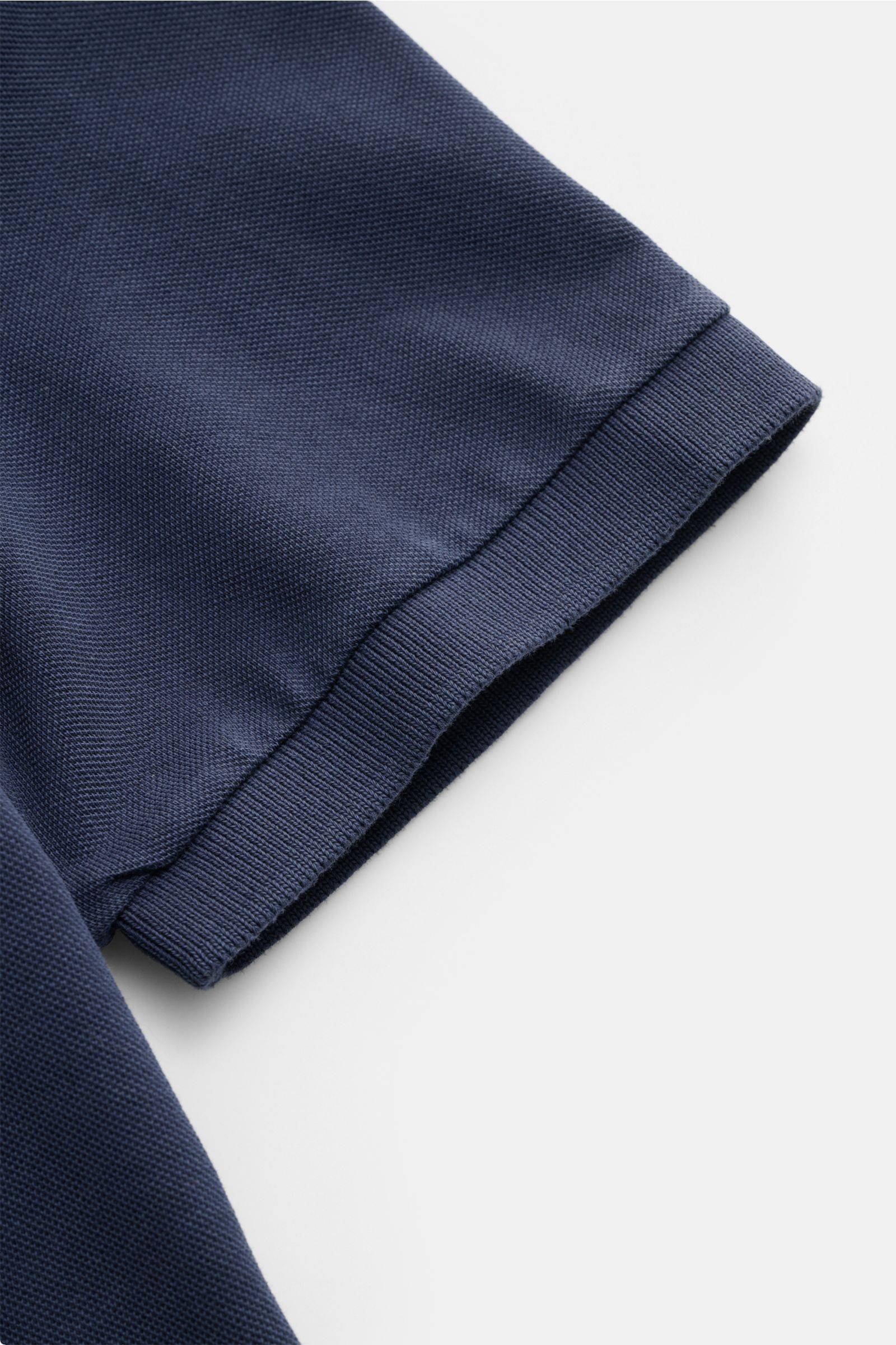 Nahaufnahme des Ärmels vom Della Ciana Poloshirt navy aus stückgefärbtem Baumwoll-Piqué mit elastischem Bündchen, seitlichem Saumsschlitz.