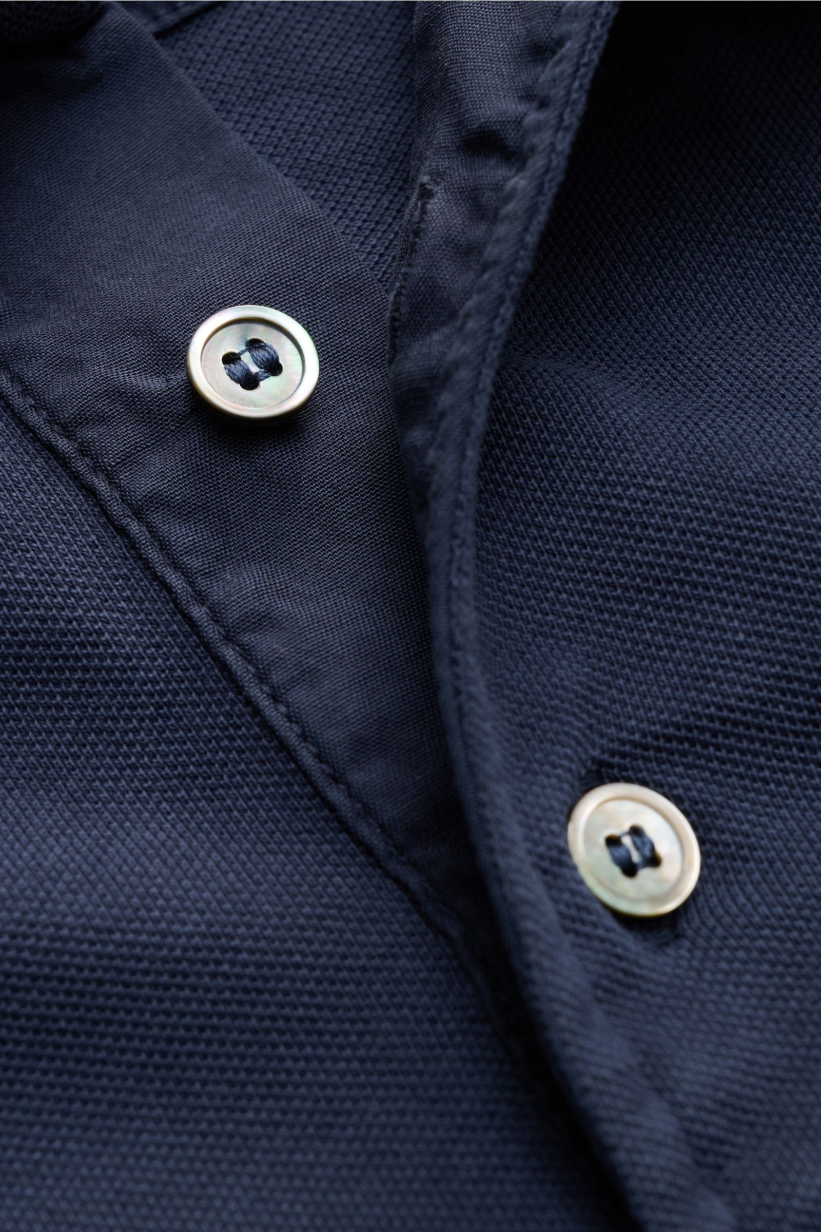 Nahaufnahme eines stückgefärbten Della Ciana Poloshirts navy in Regular Fit mit feiner Piqué-Struktur und typischer Drei-Knopf-Leiste.