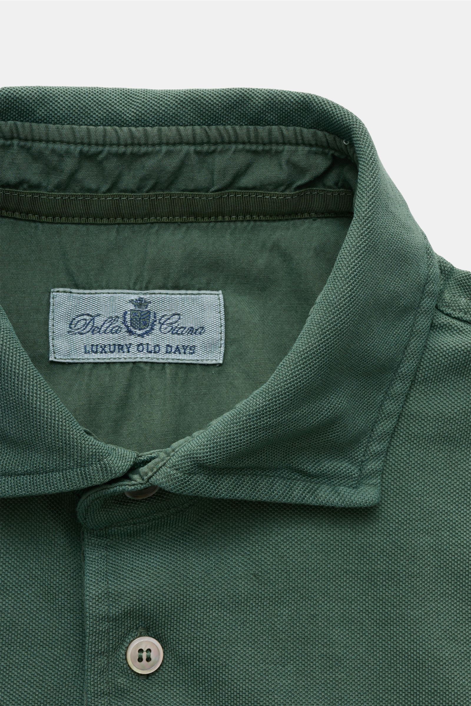 Della Ciana Poloshirt dunkelgrün, Close-up von oben auf den Baumwoll-Piqué-Kragen mit Garment dyed Effekt und Knopfleiste.