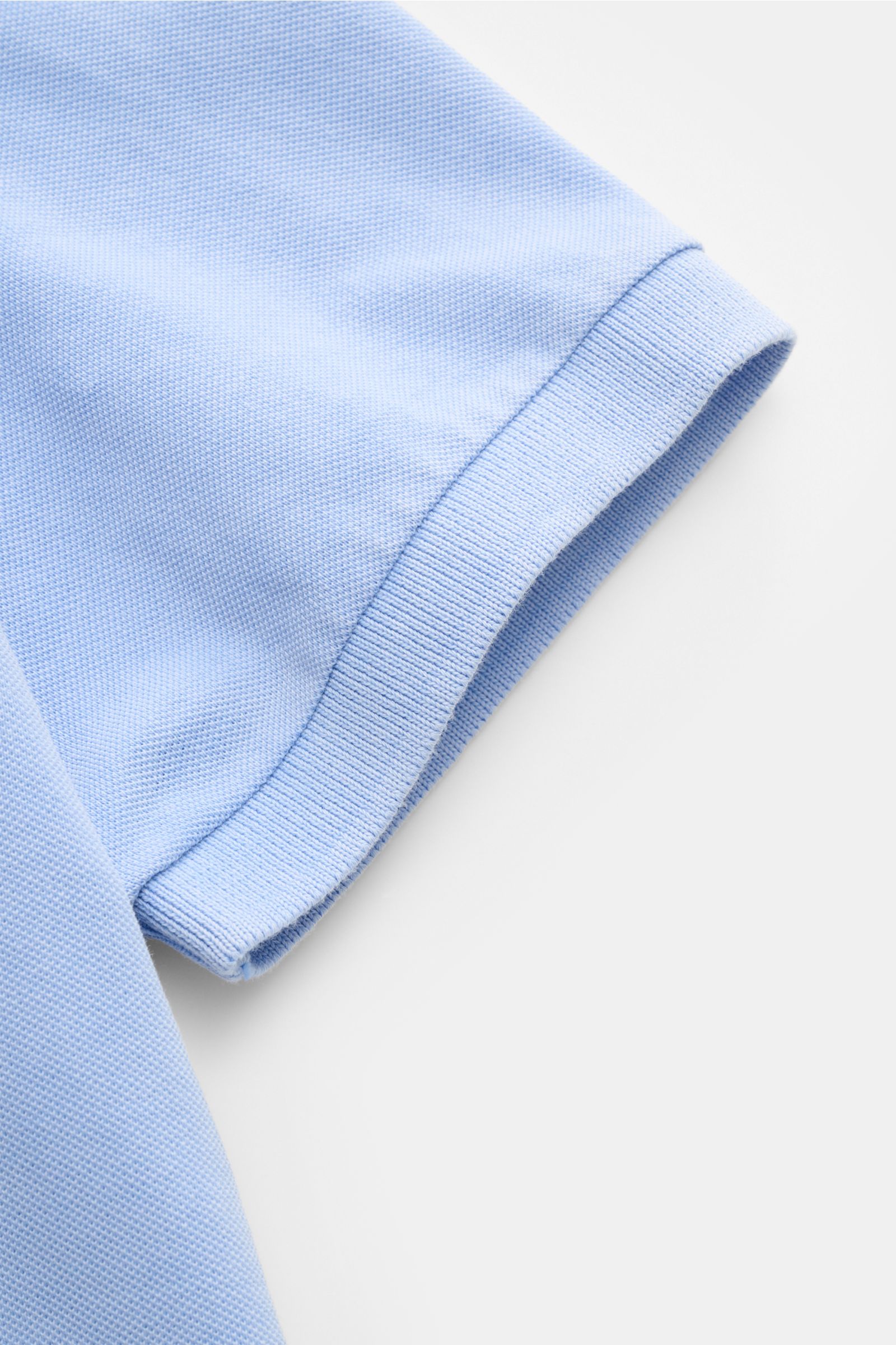 Della Ciana Poloshirt hellblau, Detailansicht Ärmelbündchen und feine Piqué-Struktur aus reiner Baumwolle, garment dyed, Regular Fit.