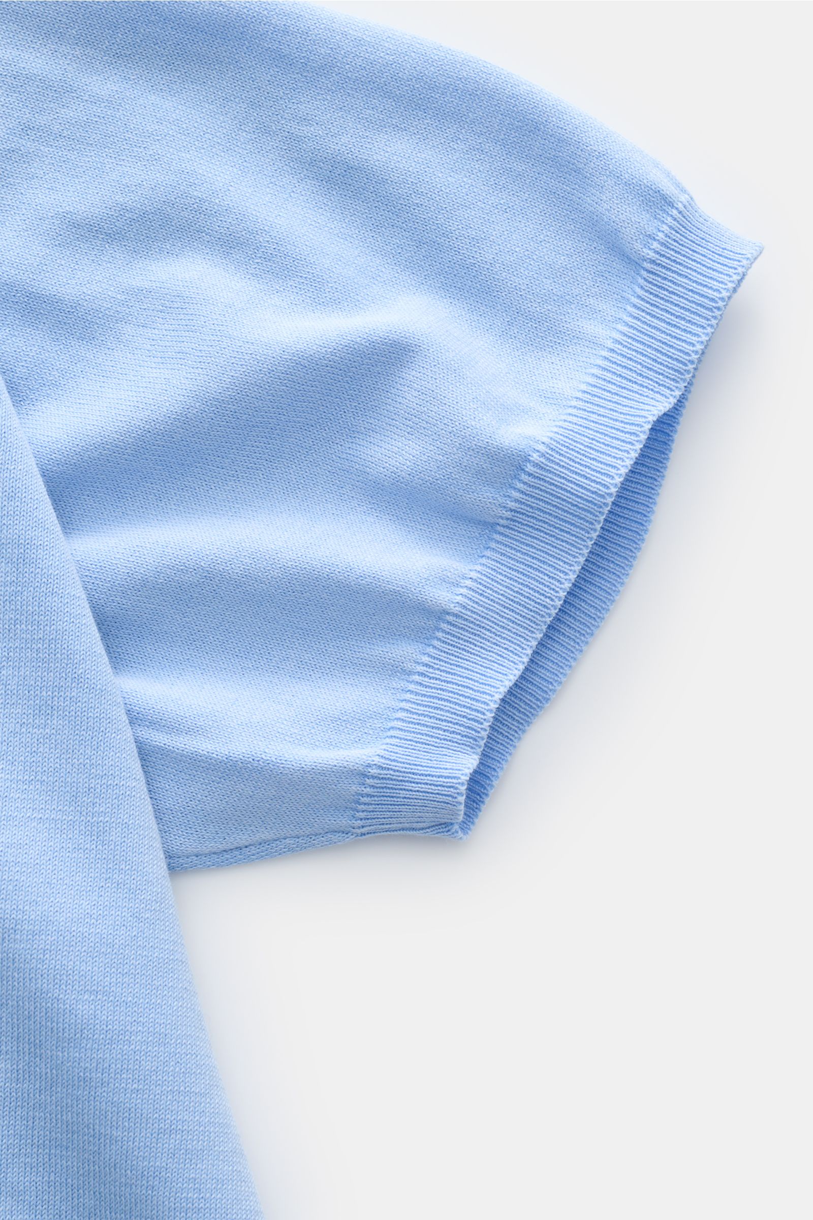 Close-up front-side view of Della Ciana Kurzarm-Strickpolo hellblau sleeve showing soft, fine cotton knit with slim fit ribbed cuff.