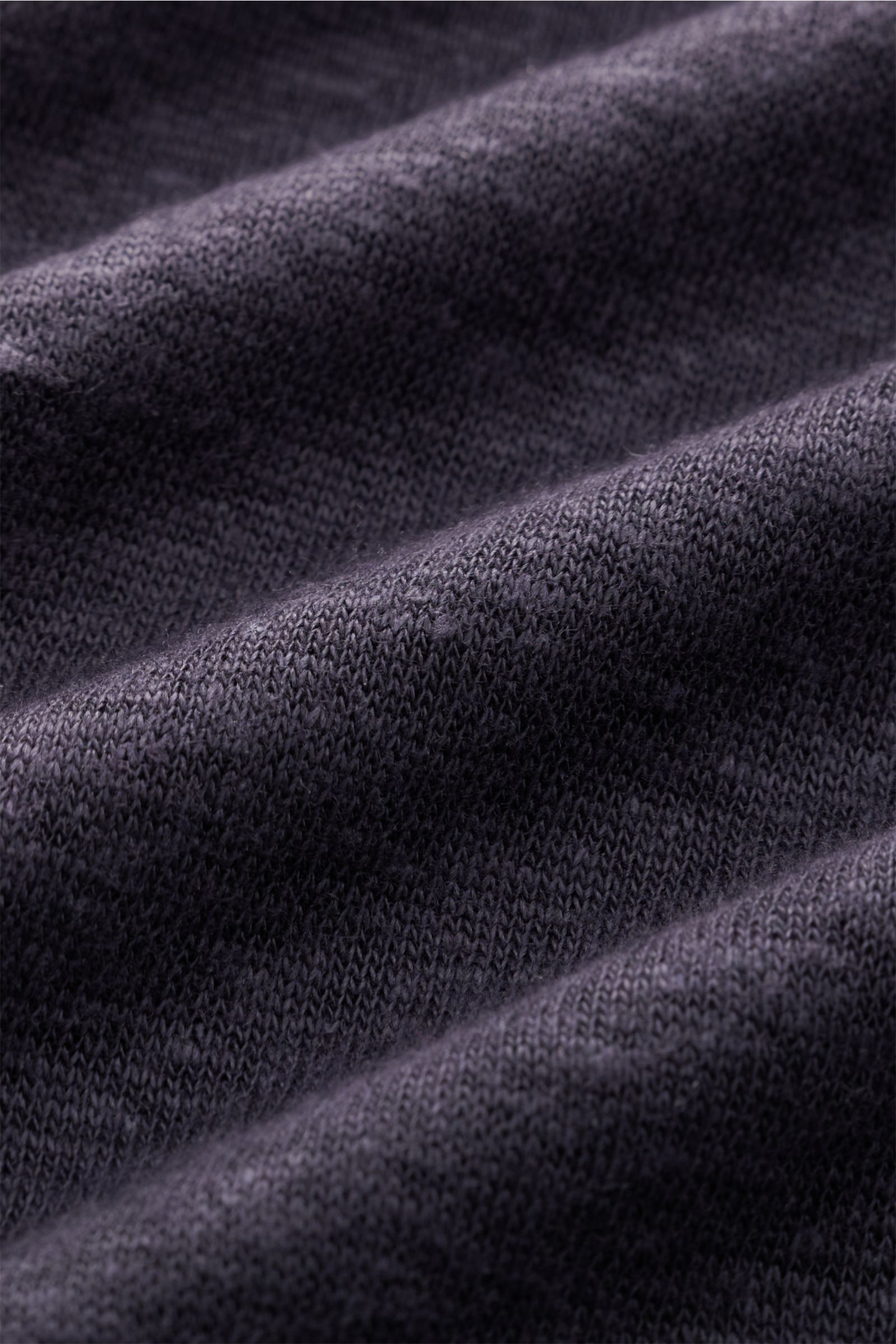 Close-up front view of the navy meliert fabric texture of the Officine Générale Kurzarm-Strickpolo 'Simon,' made from pure linen with a soft, fine knit, regular fit, and classic polo collar. Stilvoll durch die Frühlings- und Sommersaison: Das Kurzarm-Stri