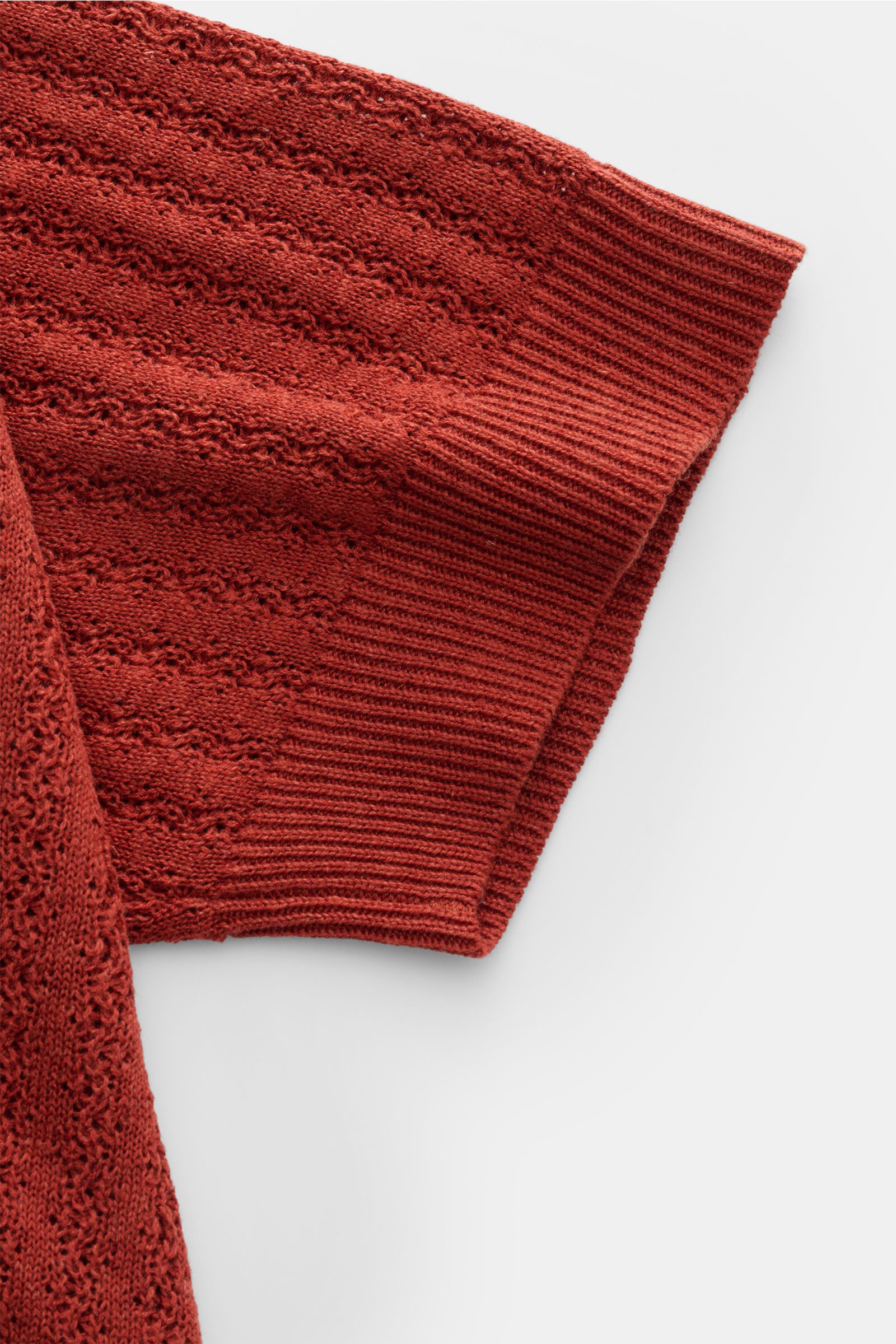 Close-up top view of the Piacenza 1733 Kurzarm-Strickpolo rostbraun sleeve, showcasing its mid-fine striped knit texture, soft silk-linen blend, regular fit, classic polo collar, and flexible ribbed cuff. Eyecatcher in der Sommersaison: Das Kurzarm-Strick