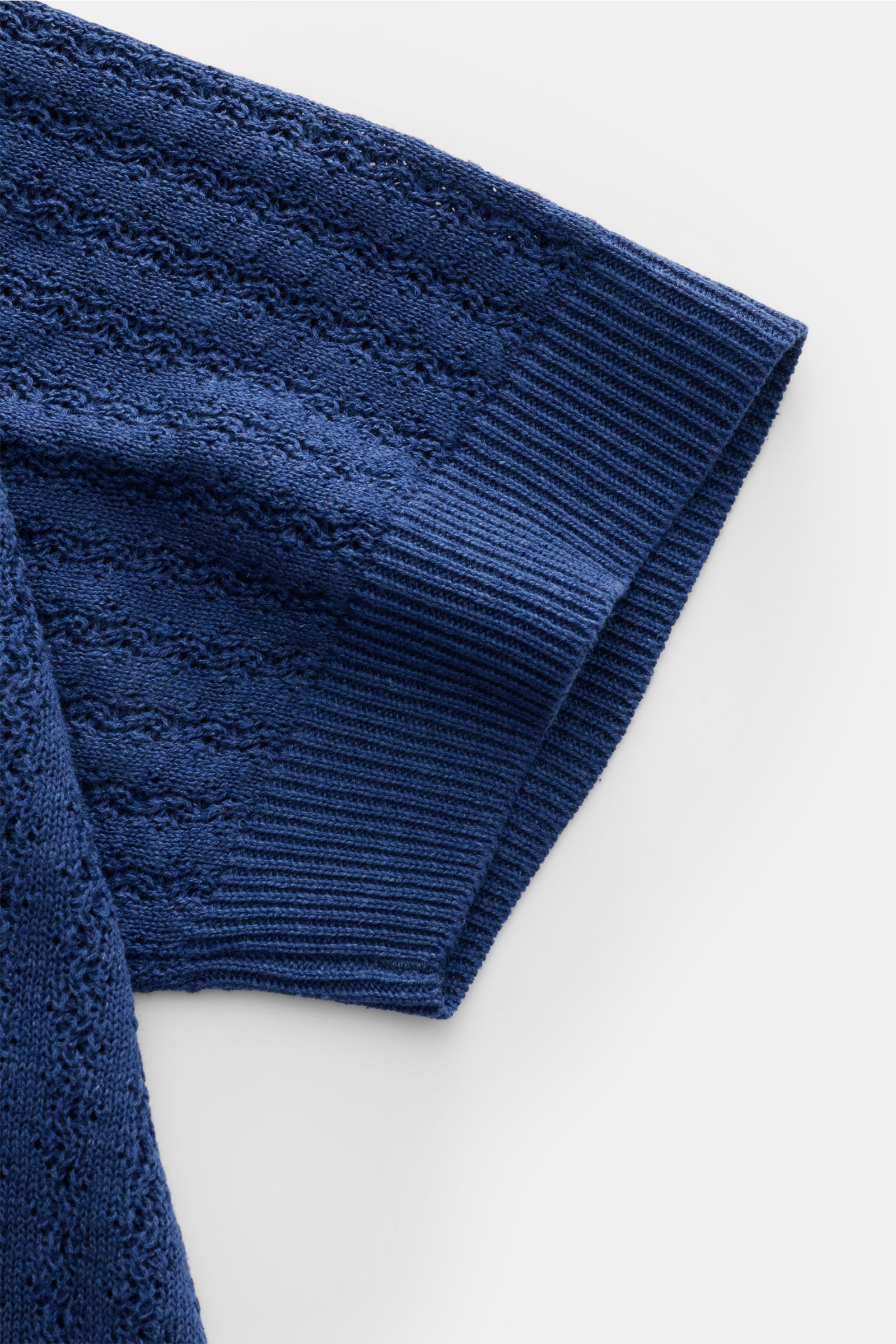 Close-up side view of the Piacenza 1733 Kurzarm-Strickpolo dunkelblau sleeve, showcasing its luxurious silk-linen blend, soft touch, medium-fine knit with striped texture, regular fit, classic polo collar, and flexible ribbed cuffs, eyecatcher in summer s