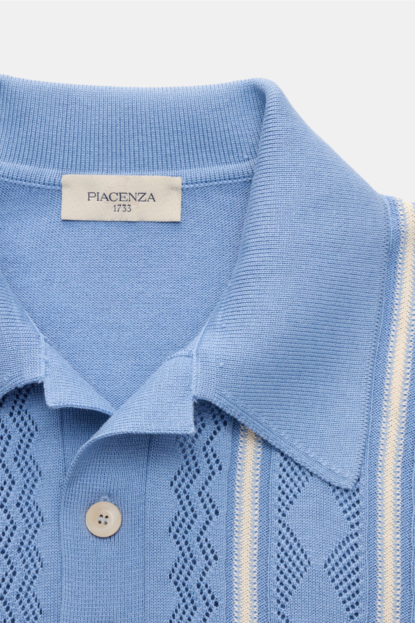 Close-up front view of Piacenza 1733 Short sleeve knit polo smoky blue with silk-cotton blend, soft feel, fine knit, perforated knit, regular fit, knit collar, two-button placket, knit contrasting stripes, and flexible ribbed bands. 

Get a tasteful lo