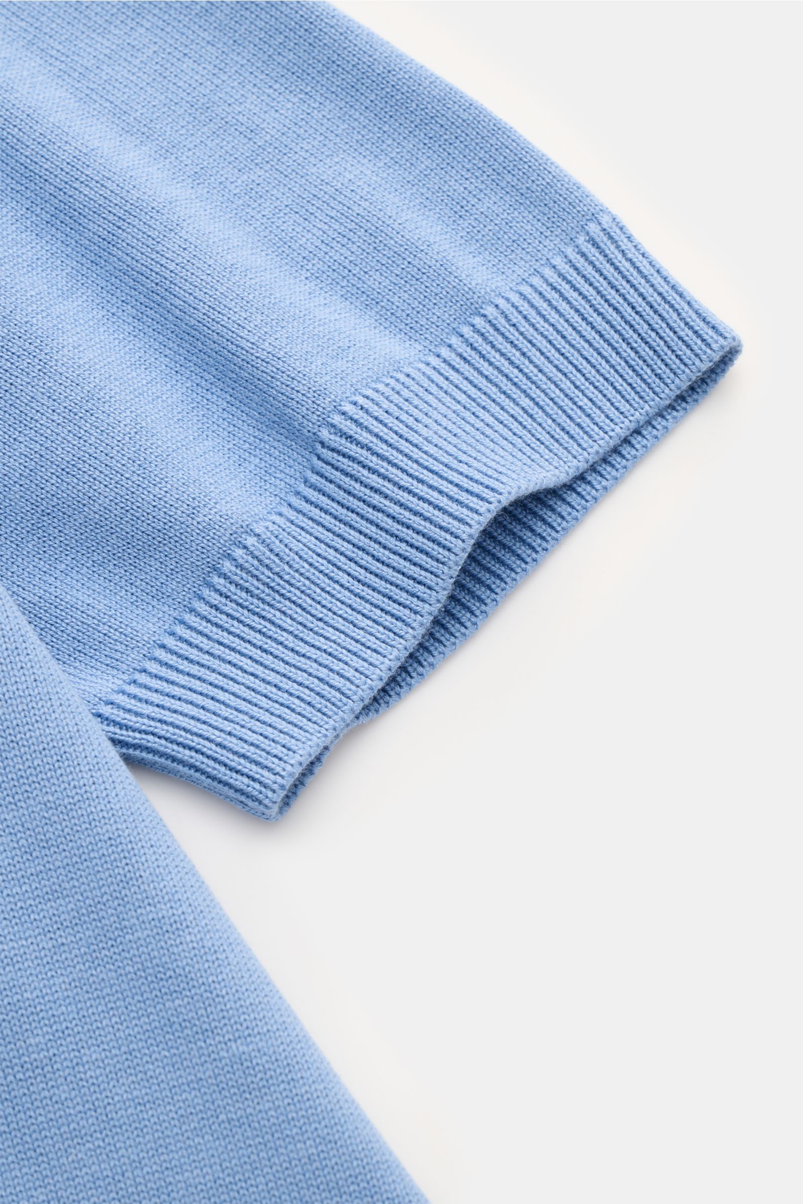 Close-up top-down view of the sleeve hem of the Piacenza 1733 Short sleeve knit polo smoky blue, showing fine silk-cotton knit with perforated pattern, soft feel, regular fit, knit collar, two-button placket, contrasting knit stripes, and flexible ribbed 