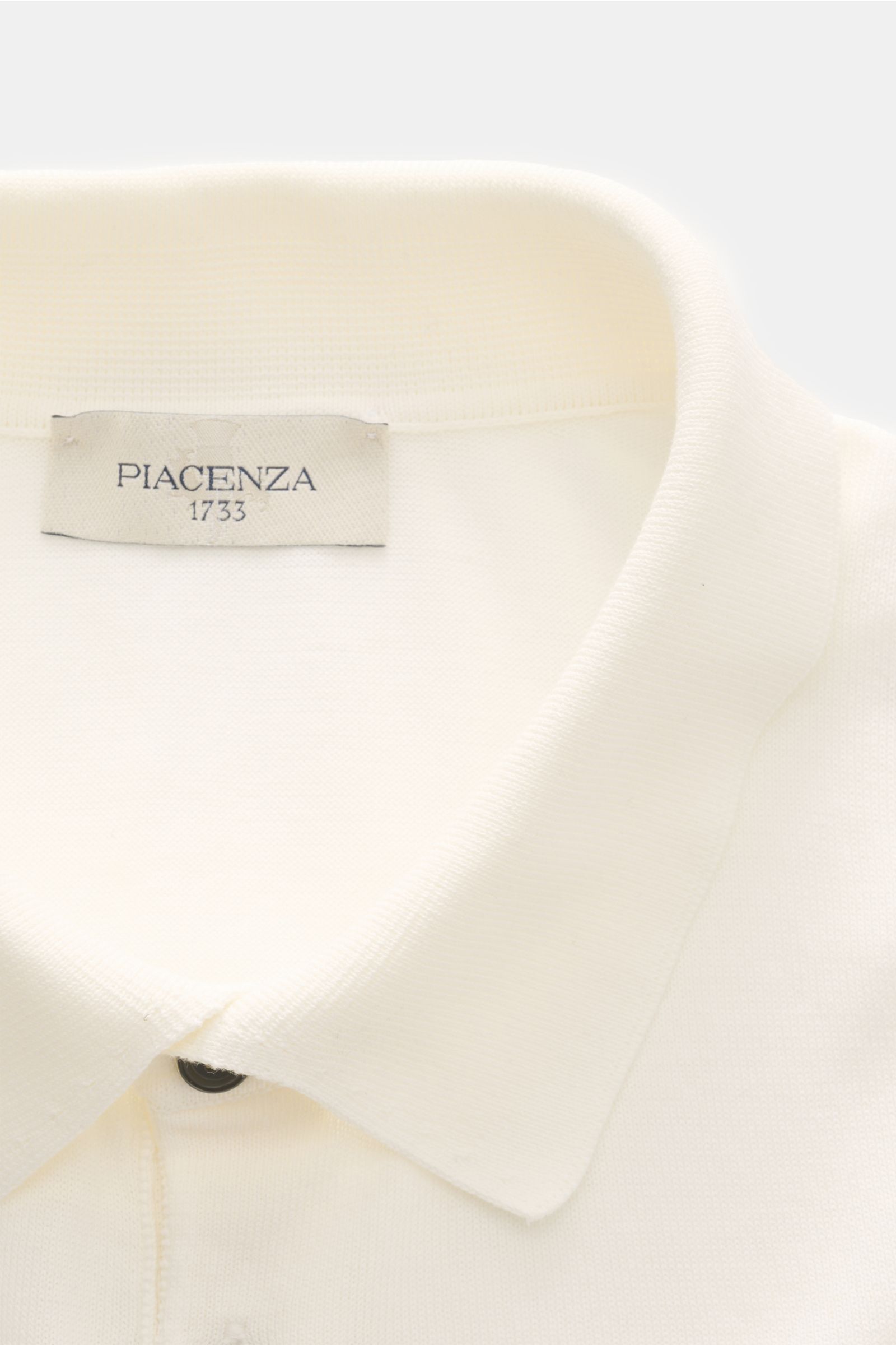 Piacenza 1733 Kurzarm-Strickpolo offwhite, Nahaufnahme von oben, Polokragen, Drei-Knopf-Leiste, Feinstrick aus reiner Baumwolle, Slim Fit, weicher Griff, Rippbündchen