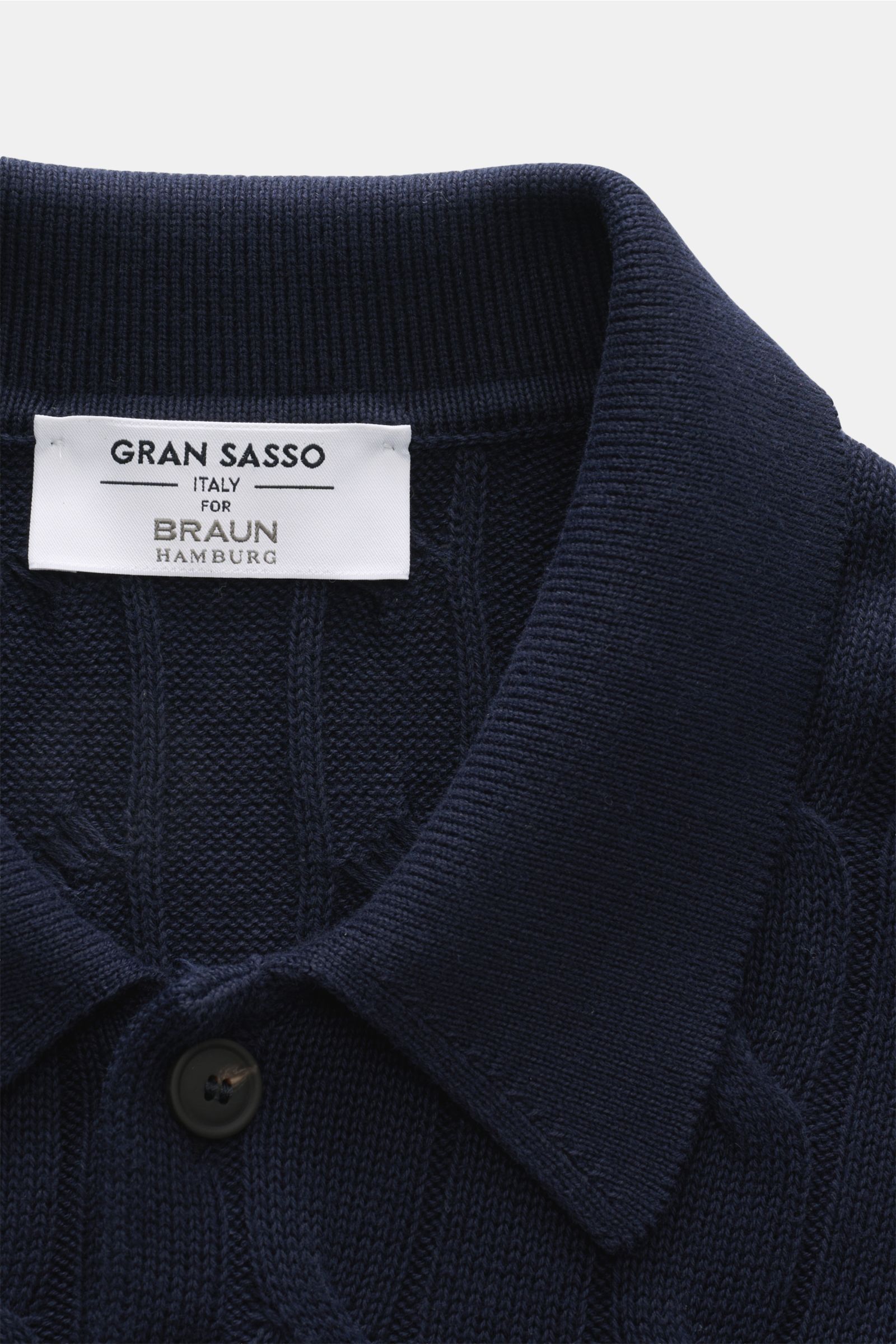 Close-up top view of the Gran Sasso Short sleeve knit polo shirt navy collar and label, showing classic cable knit pattern and button. Perfect for hot days: This short sleeve knit polo by GRAN SASSO in an exclusive design for BRAUN HAMBURG is made of comf