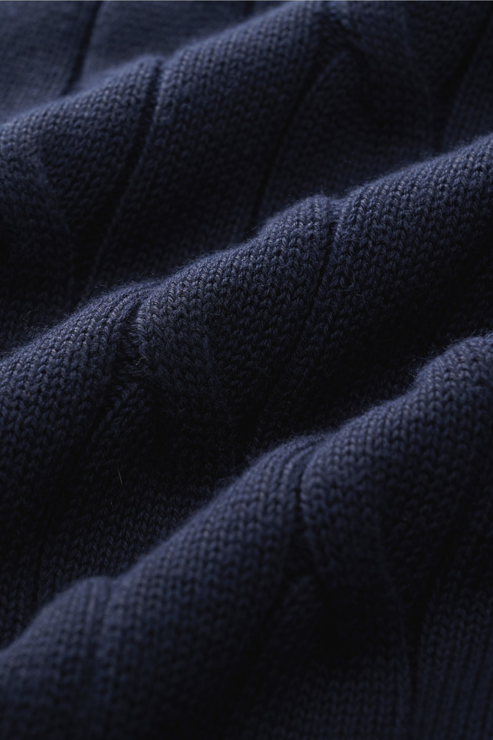 Close-up view of navy cable knit fabric showcasing texture and detail of the Gran Sasso Short sleeve knit polo shirt navy. Perfect for hot days: This short sleeve knit polo by GRAN SASSO in an exclusive design for BRAUN HAMBURG is made of comfortable cott