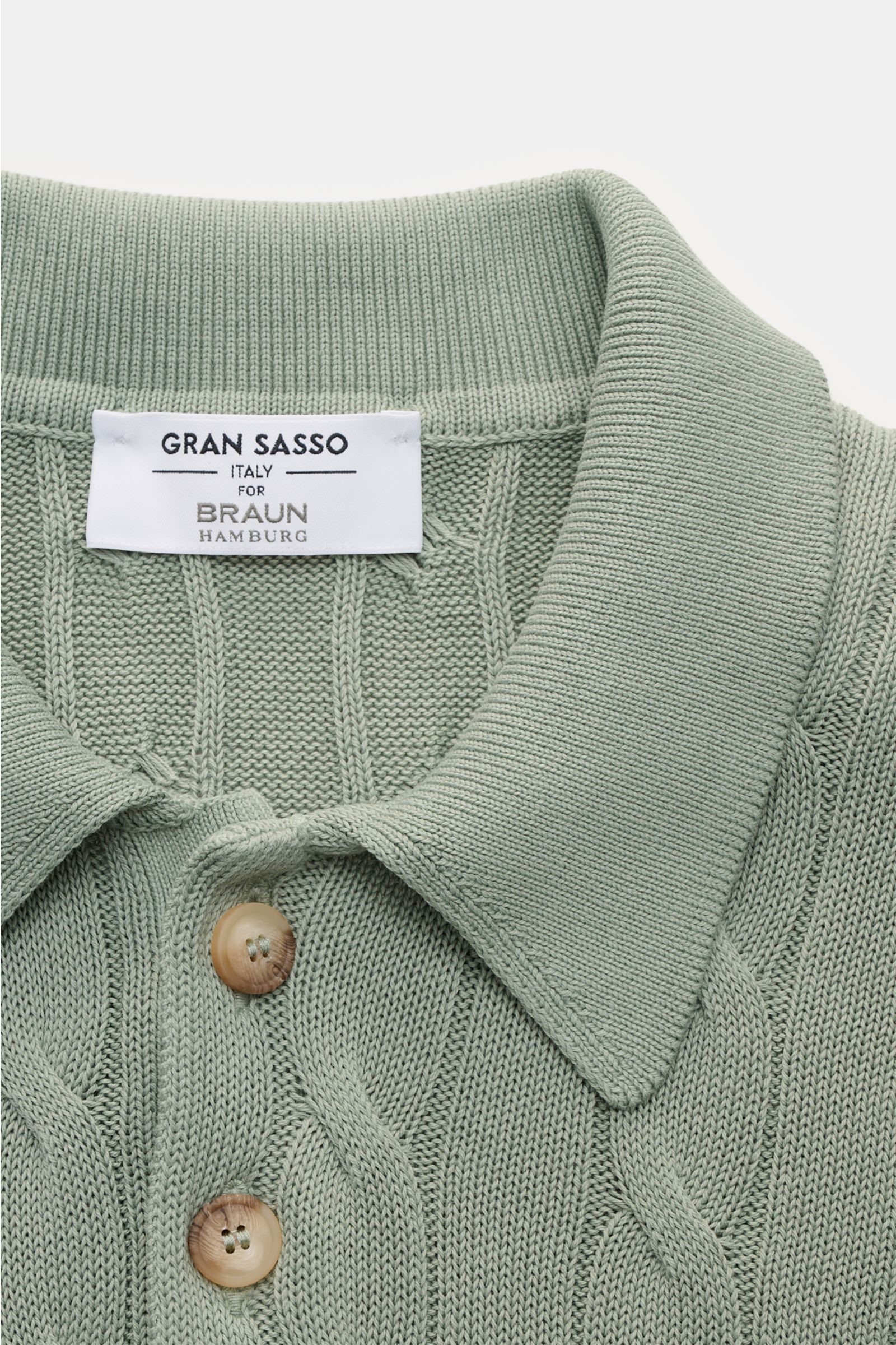 Close-up front view of the Gran Sasso Kurzarm-Strickpolo salbei, a slim-fit short-sleeve knit polo in sage green with classic cable knit pattern, soft pure cotton, ribbed collar, and beige buttons, ideal for warm days with flexible ribbed cuffs and a medi