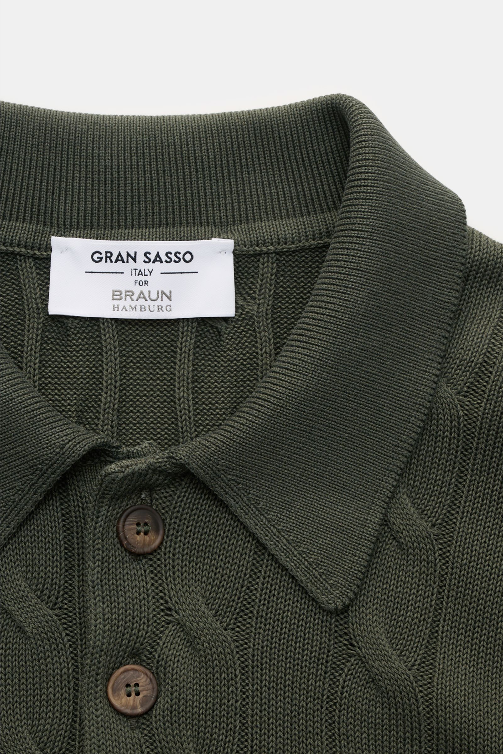 Gran Sasso Kurzarm-Strickpolo dunkelgrün shown from a top front close-up, featuring a classic polo collar, cable knit pattern, and brown buttons. Ideal für warme Tage: Das Kurzarm-Strickpolo von GRAN SASSO in exklusiver Fertigung für BRAUN HAMBURG überzeu