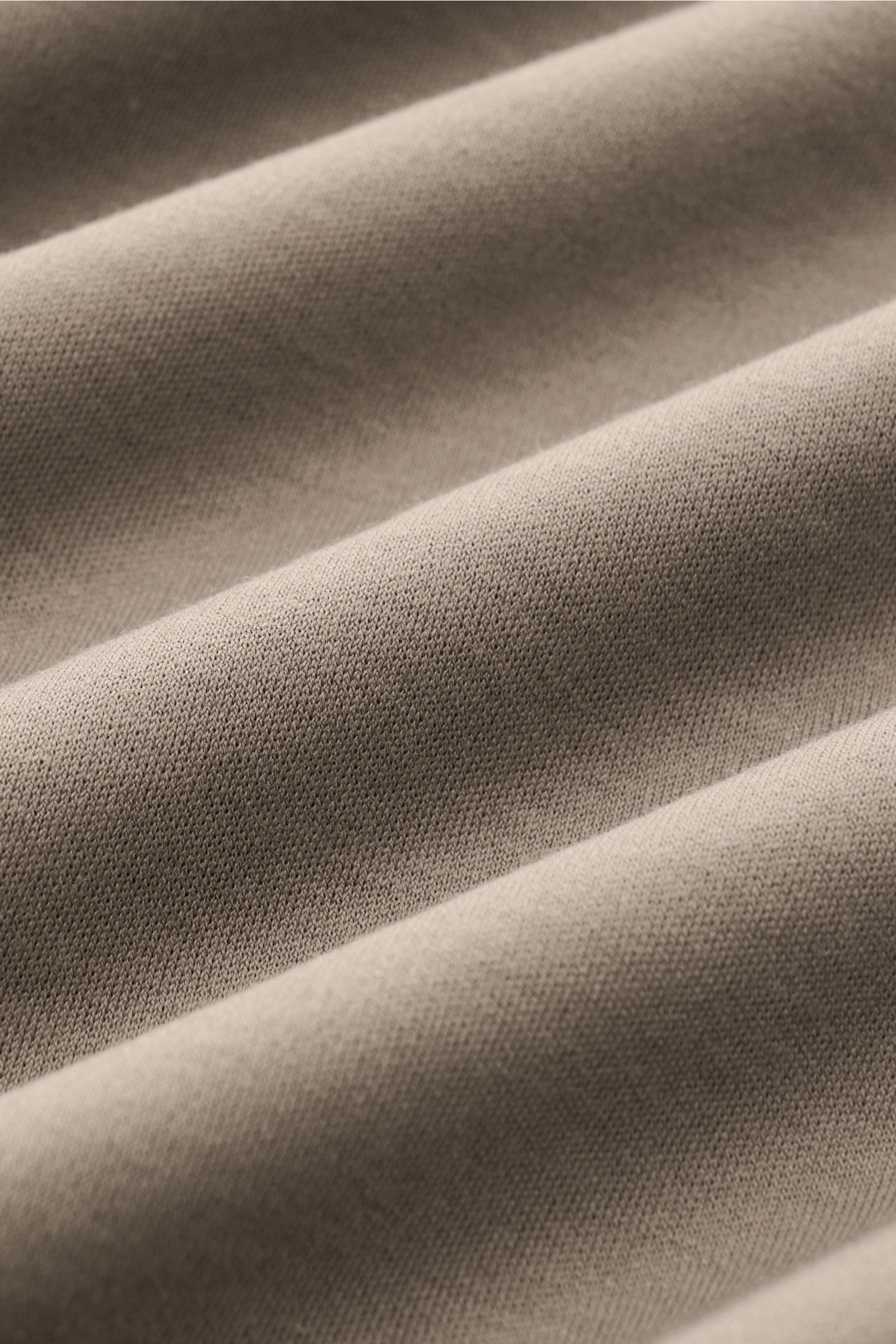 Nahaufnahme des weichen, olivfarbenen Gran Sasso Jersey-Poloshirts aus reiner Baumwolle mit klassischem Polokragen in Slim Fit, seitliche Stofffalten sichtbar, Frontperspektive.