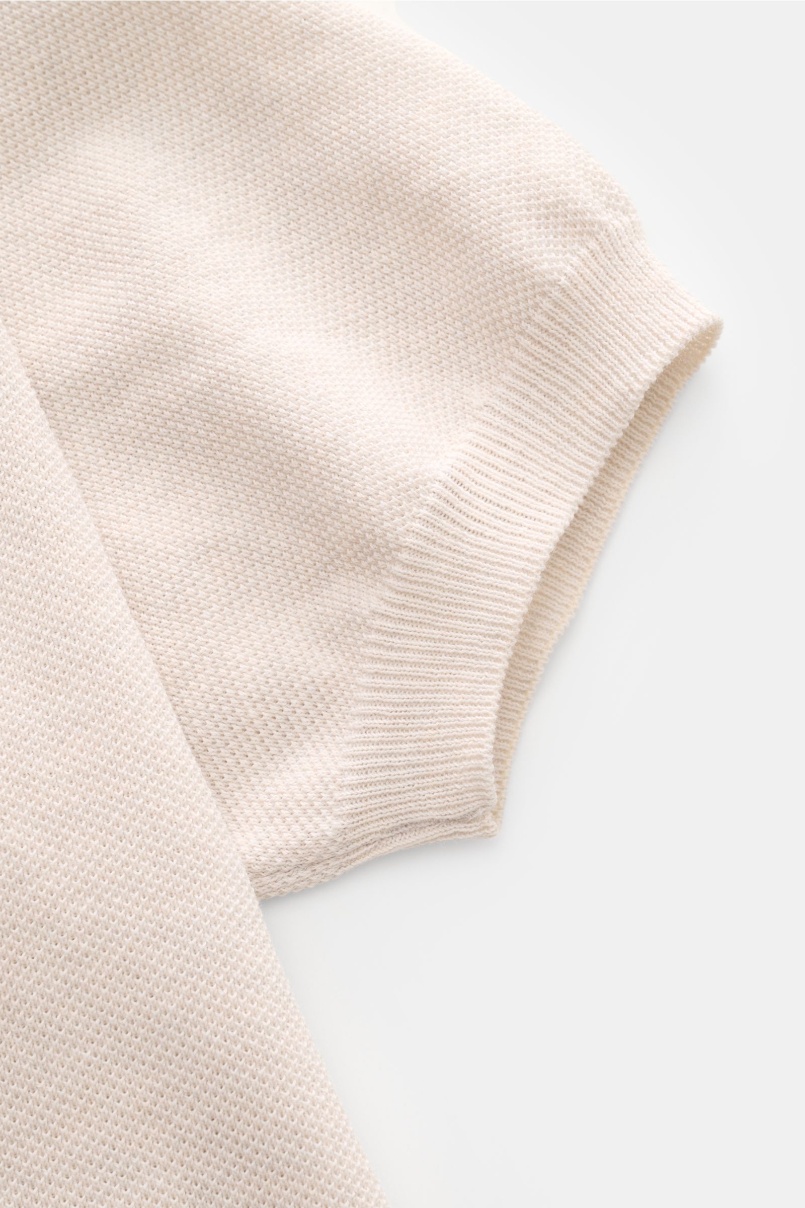 Gran Sasso Poloshirt sand meliert, Nahaufnahme des kurzärmligen Baumwoll-Piqué mit elastischem Rippbündchen, Slim Fit, seitliche Perspektive.