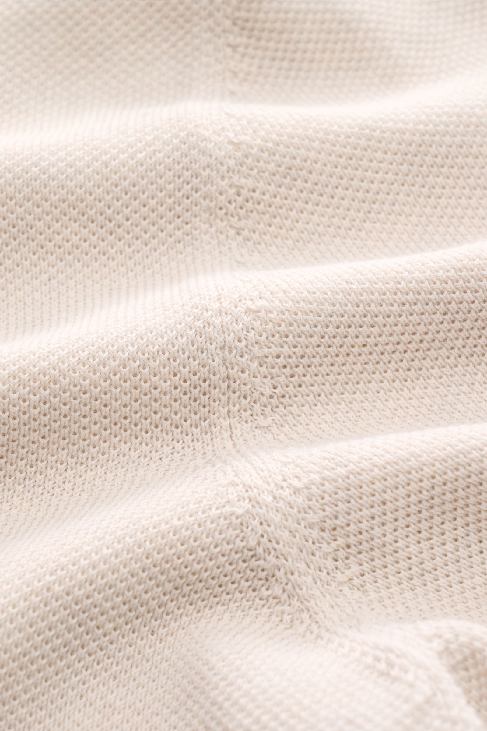 Nahaufnahme des Gran Sasso Poloshirts sand meliert, zeigt strukturierte, atmungsaktive Baumwoll-Piqué-Qualität in sanfter Wellenperspektive.