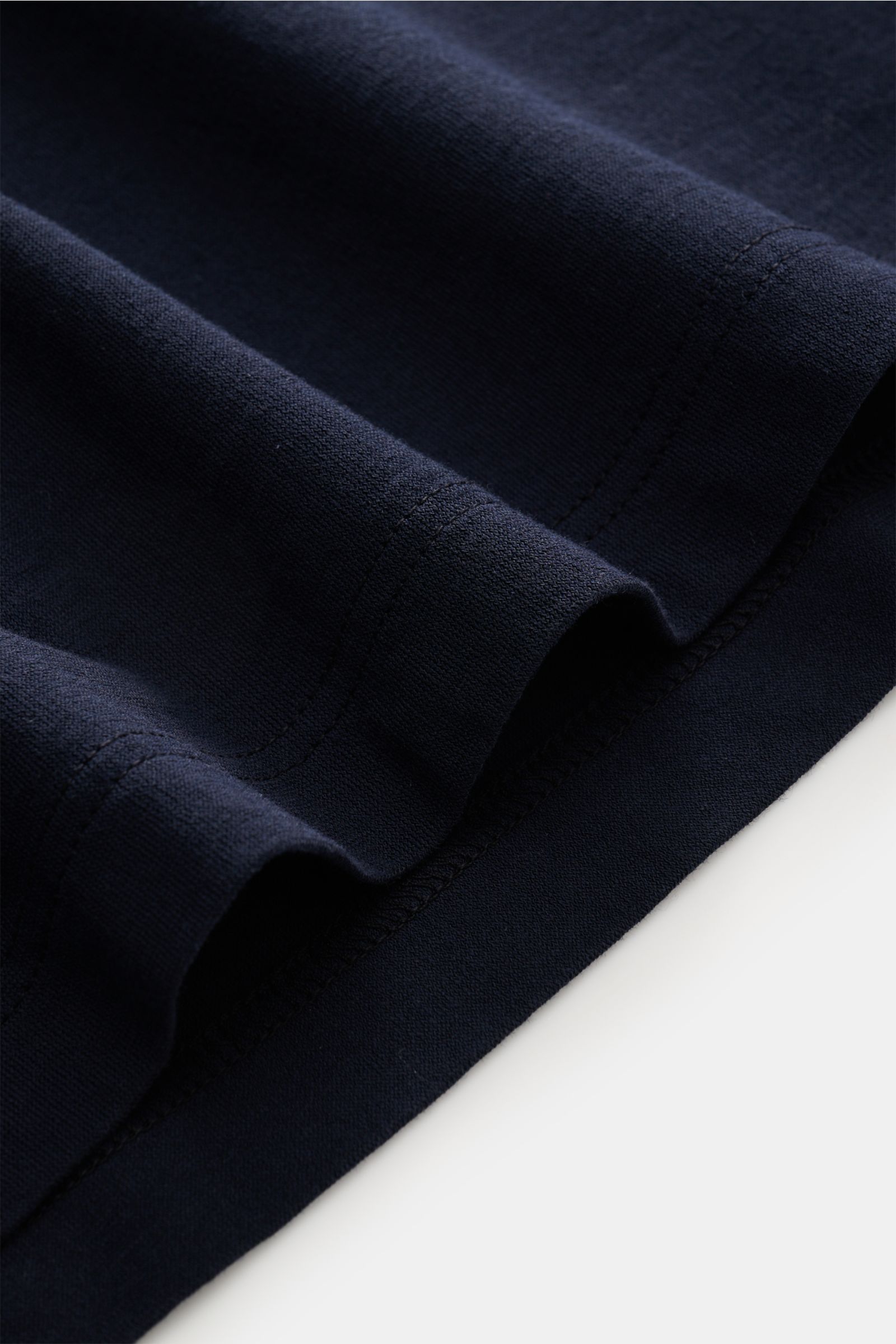 Close-up side view of the navy fabric and hem of the BRAUN Hamburg Jersey polo shirt navy, showing fine cotton jersey texture and stitching.

Description: 
Sporty style for the new season: BRAUN HAMBURG has processed pure cotton into fine jersey to mak