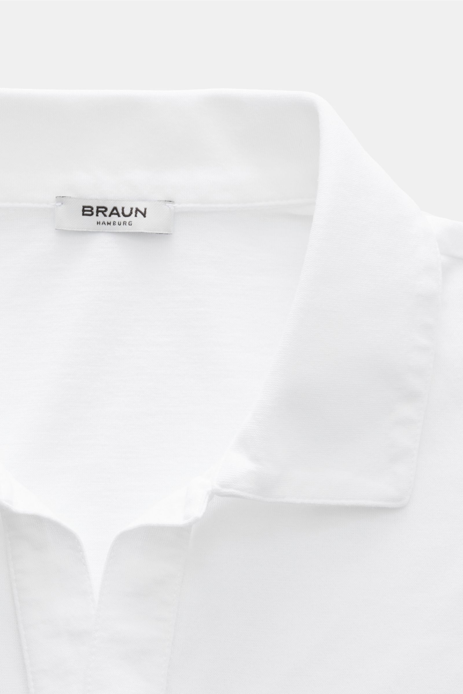 Close-up front view of the collar and label of the BRAUN Hamburg Jersey-polo shirt white, sporty style with open collar placket.

Description: Sporty style for the new season: BRAUN HAMBURG has processed pure cotton into fine jersey to make this polo shir