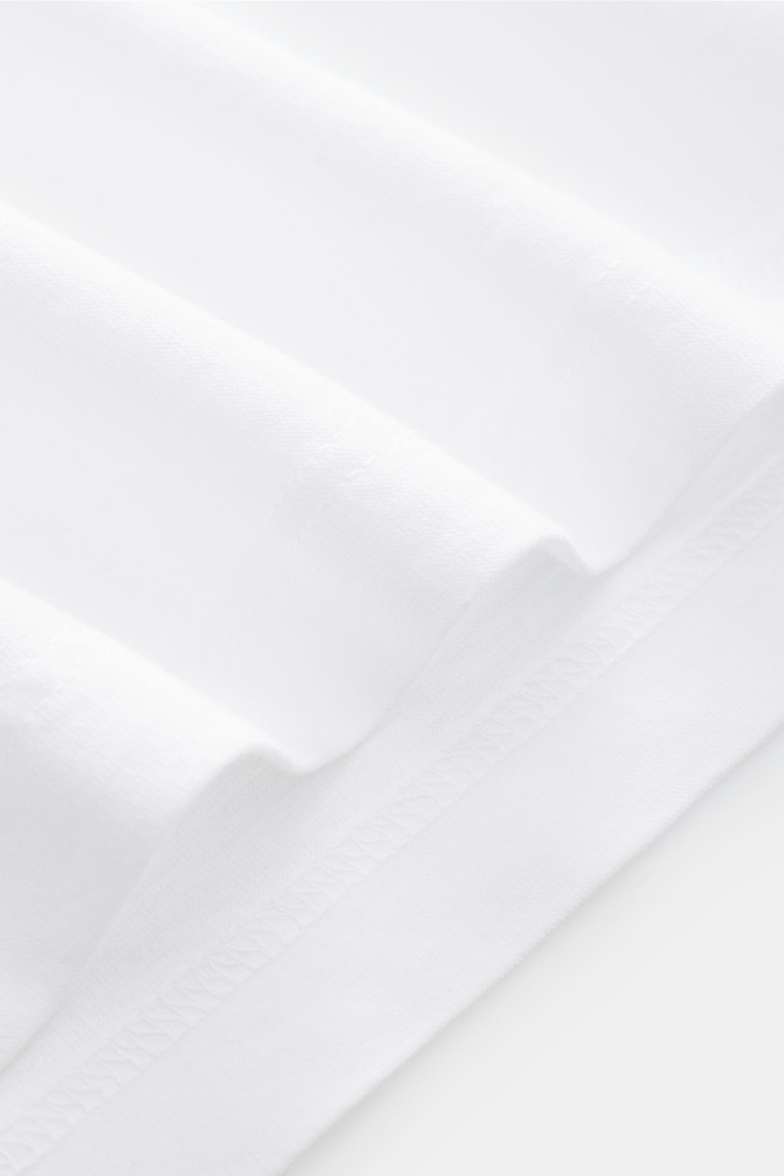 Close-up front view of BRAUN Hamburg Jersey-polo shirt white showing fine cotton jersey fabric, slim fit, shark collar, open placket, and side vents. Sporty style for the new season: BRAUN HAMBURG has processed pure cotton into fine jersey to make this po