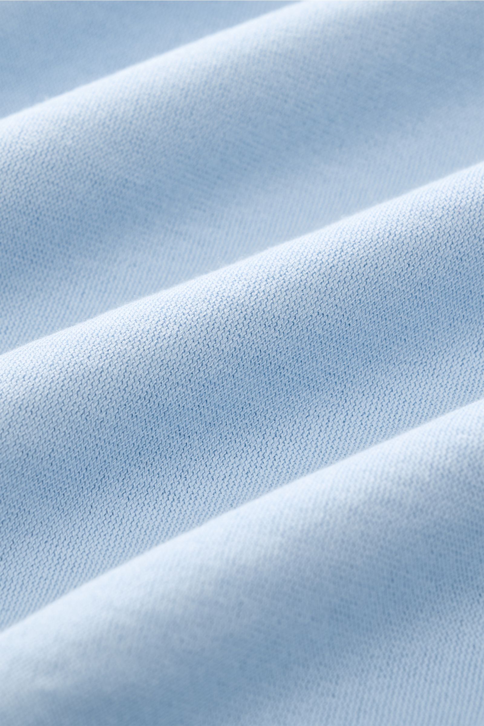 Close-up angled view of light blue fabric texture showing fine jersey material of BRAUN Hamburg Jersey polo shirt light blue.

Description: 
Sporty style for the new season: BRAUN HAMBURG has processed pure cotton into fine jersey to make this polo shi