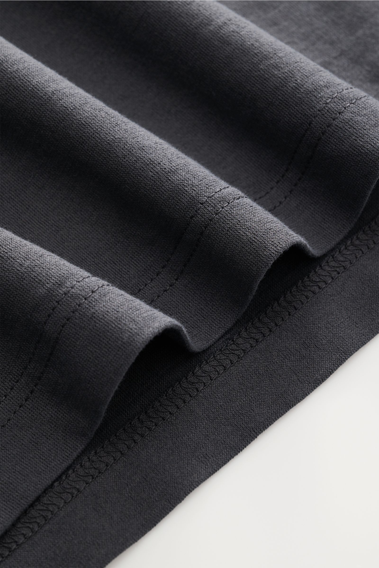 Close-up front view of the slightly robust dark grey fabric and stitching of the BRAUN Hamburg Jersey polo shirt dark grey.

Description:  
Sporty style for the new season: BRAUN HAMBURG has processed pure cotton into fine jersey to make this polo shir