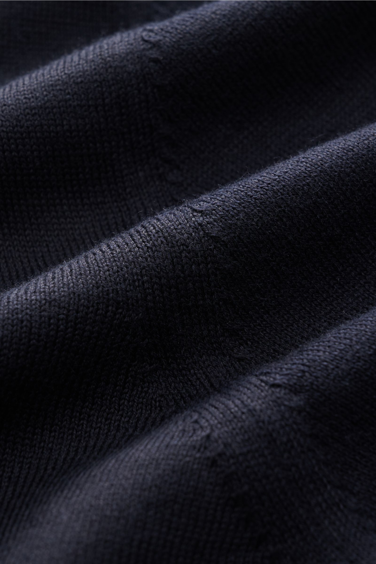 Nahaufnahme des fein gestrickten Stoffes des BRAUN Hamburg Kurzarm-Strickpolo dark navy, aufgenommen aus schräger Perspektive.