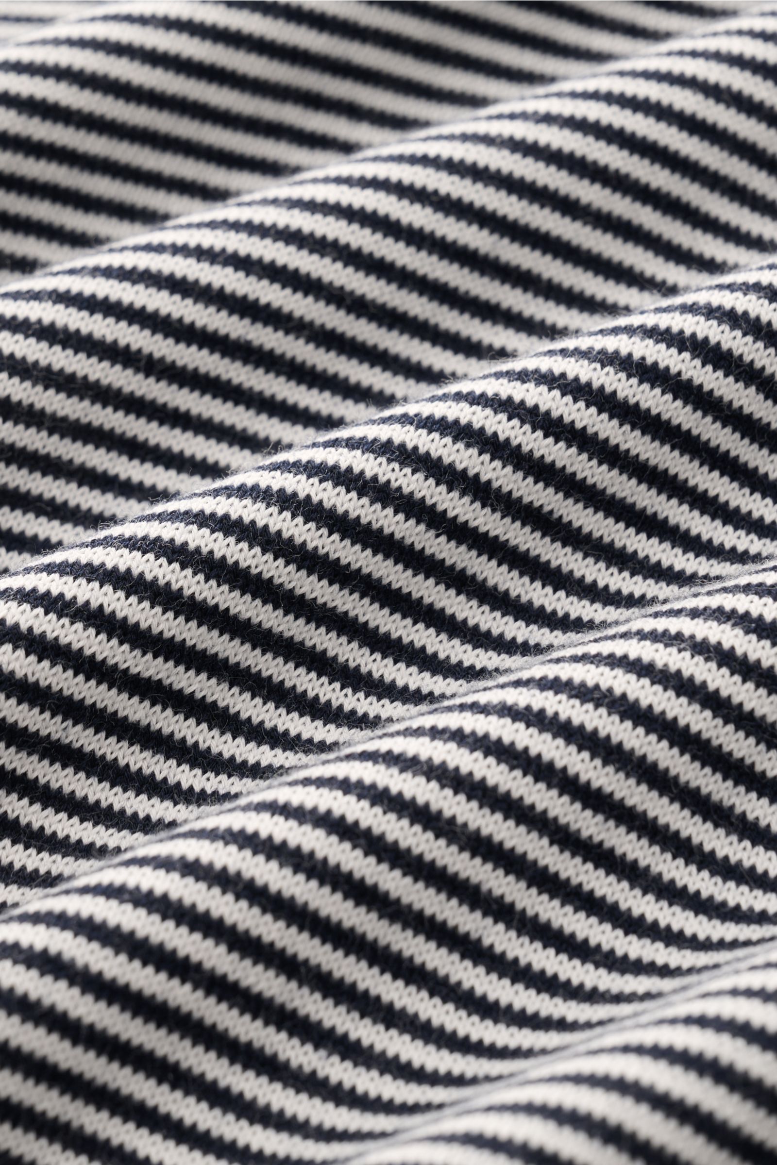 Close-up front view of the fabric texture of the BRAUN Hamburg Short-sleeve knit polo navy/white striped showing fine, soft cotton knit with precise navy and white stripes.

Nautical style gets a modern interpretation: This BRAUN HAMBURG knit polo in p